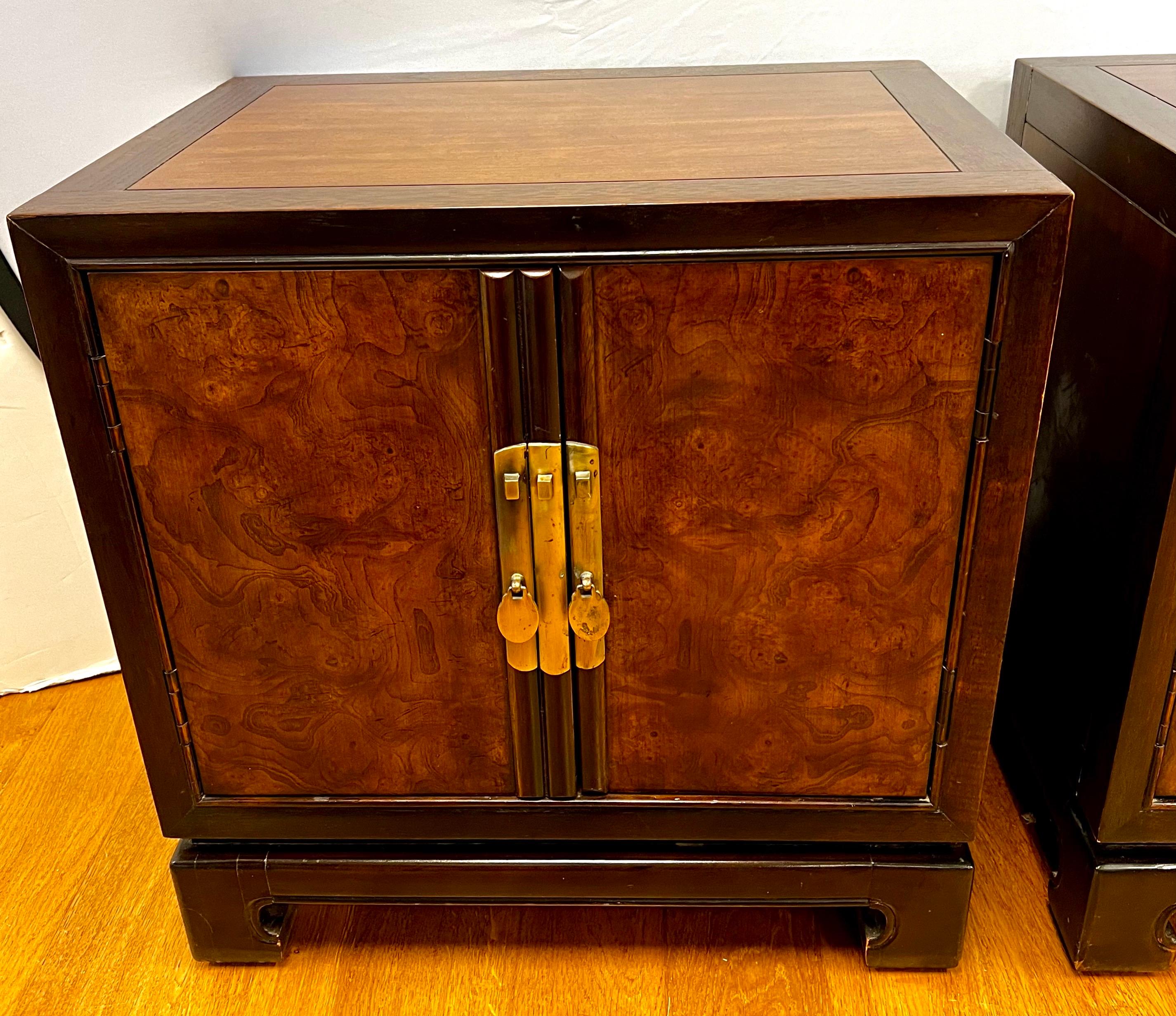 Pair of luxurious and coveted Chinoiserie style nightstands by Drexel Heritage, from their sought after Tai-Ming Collection.  Features solid wood lacquered with decorative brass hardware and bracket feet.  Two solid doors open to reveal a cabinet