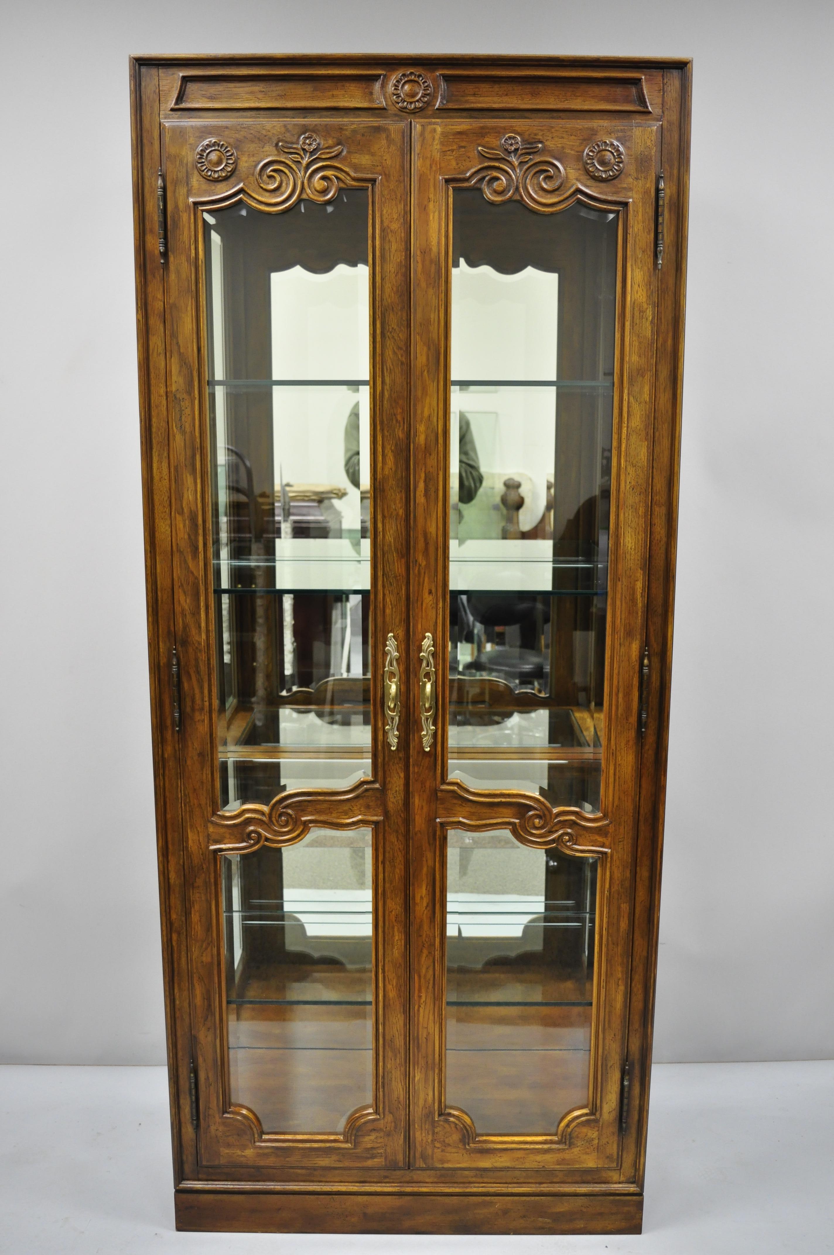 Pair of Drexel heritage old continent lighted curio China cabinets. Listing includes (2 curios) solid wood construction, nicely carved details, lighted interior with dimmer, 2 swing doors, beveled glass, plate groves, 4 adjustable glass shelves,