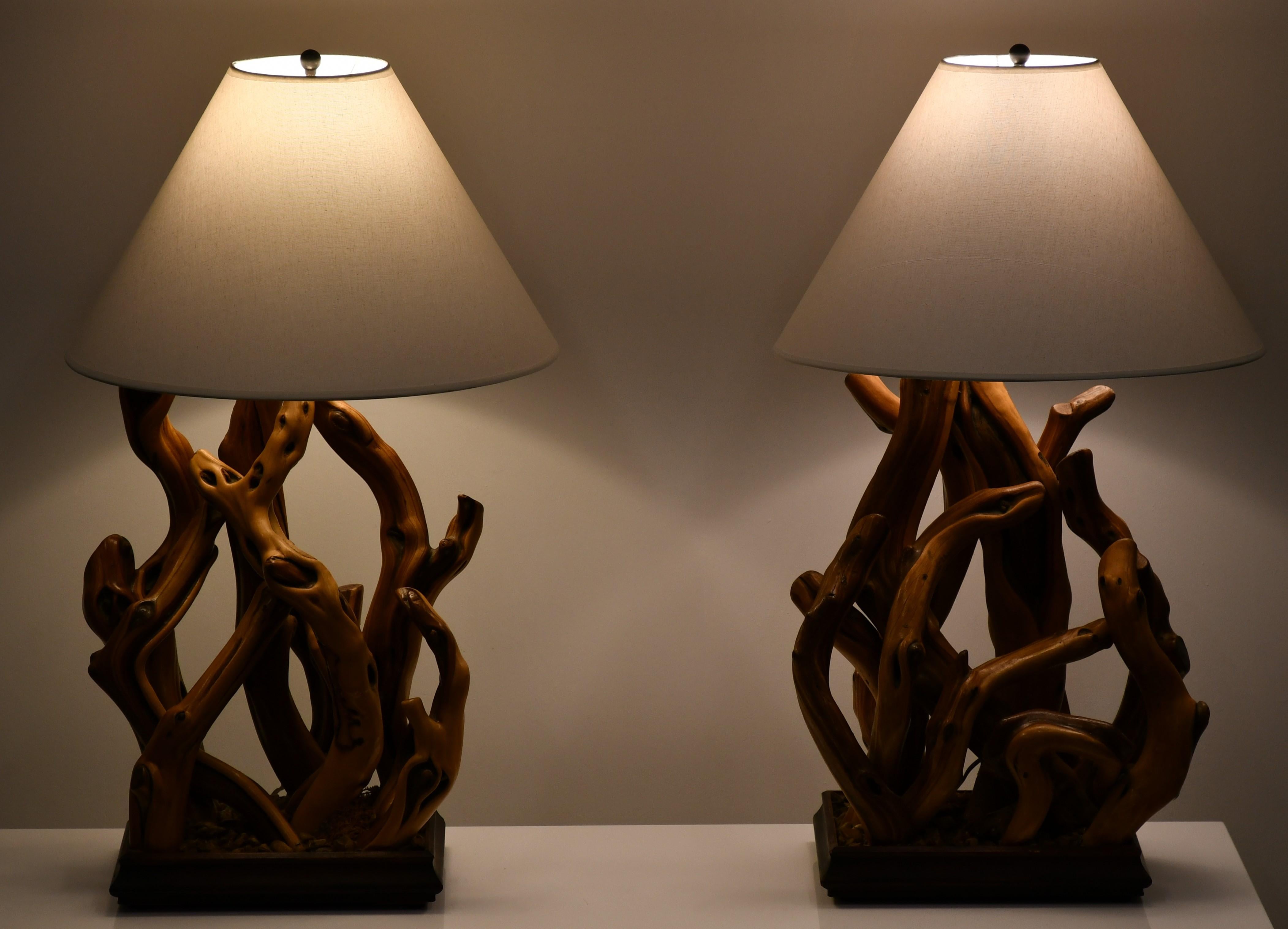 A unique pair of driftwood table lamps on wooden bases with stone detail. Lampshades are not included. Lamps have original harps but they can be changed to adjust the size. 

Dimensions: 32.5
