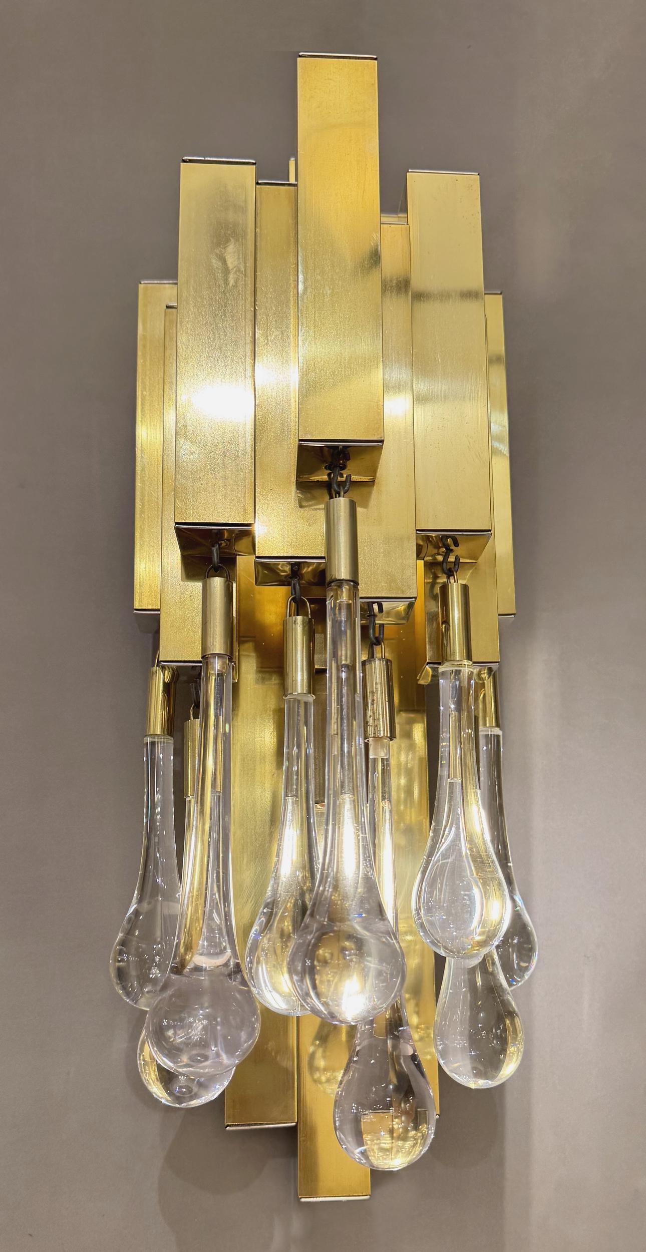Pair of “gouttes” sconces, by Lumica in Barcelona, circa 1970. The sconces feature a structure of polished brass square tubes finished with chrome-plated cabochons. Each sconce supports nine solid glass drops concealing a light bulb. A second light,