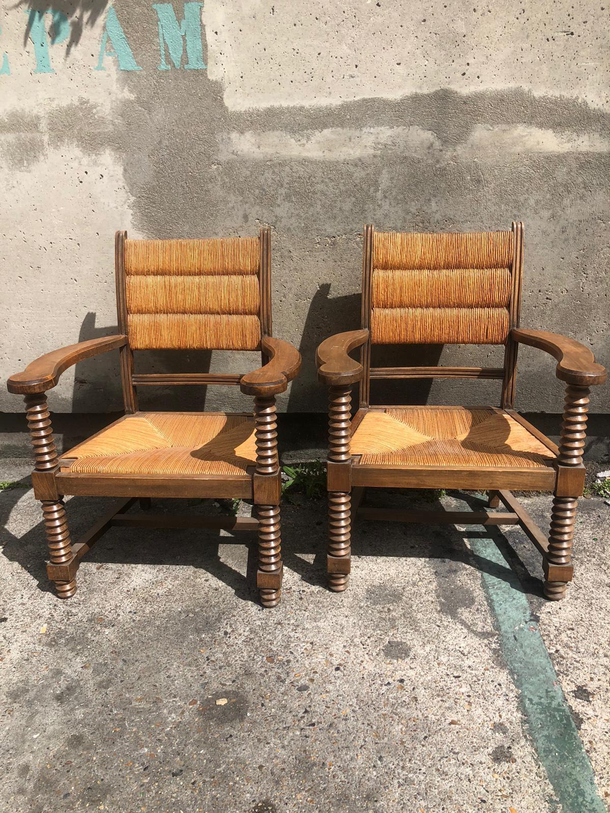 A pair of Dudouyt armchairs in oak and straw.