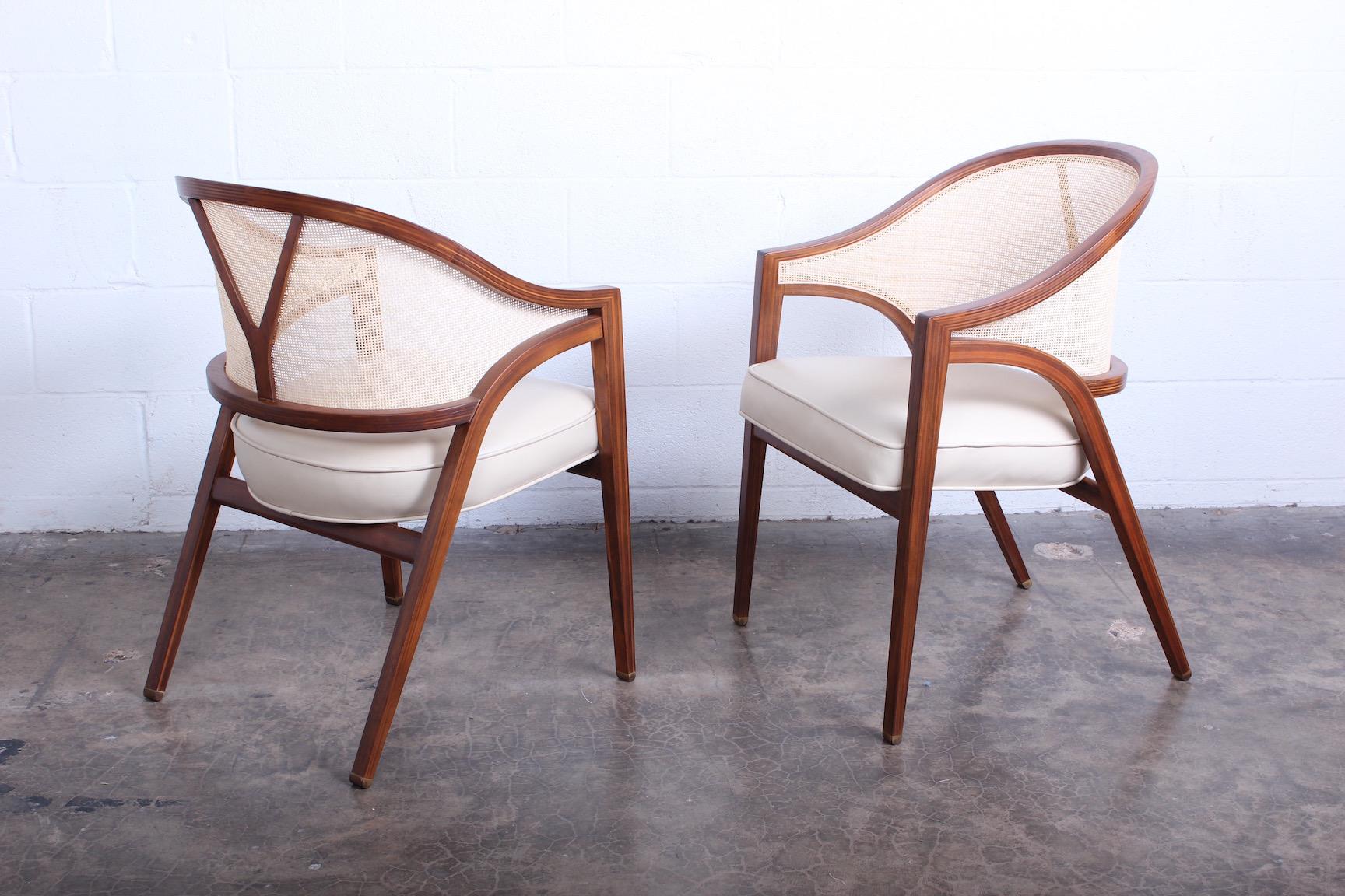 A pair of cane back armchairs designed by Edward Wormley. Walnut with original leather seats. Two pairs available.