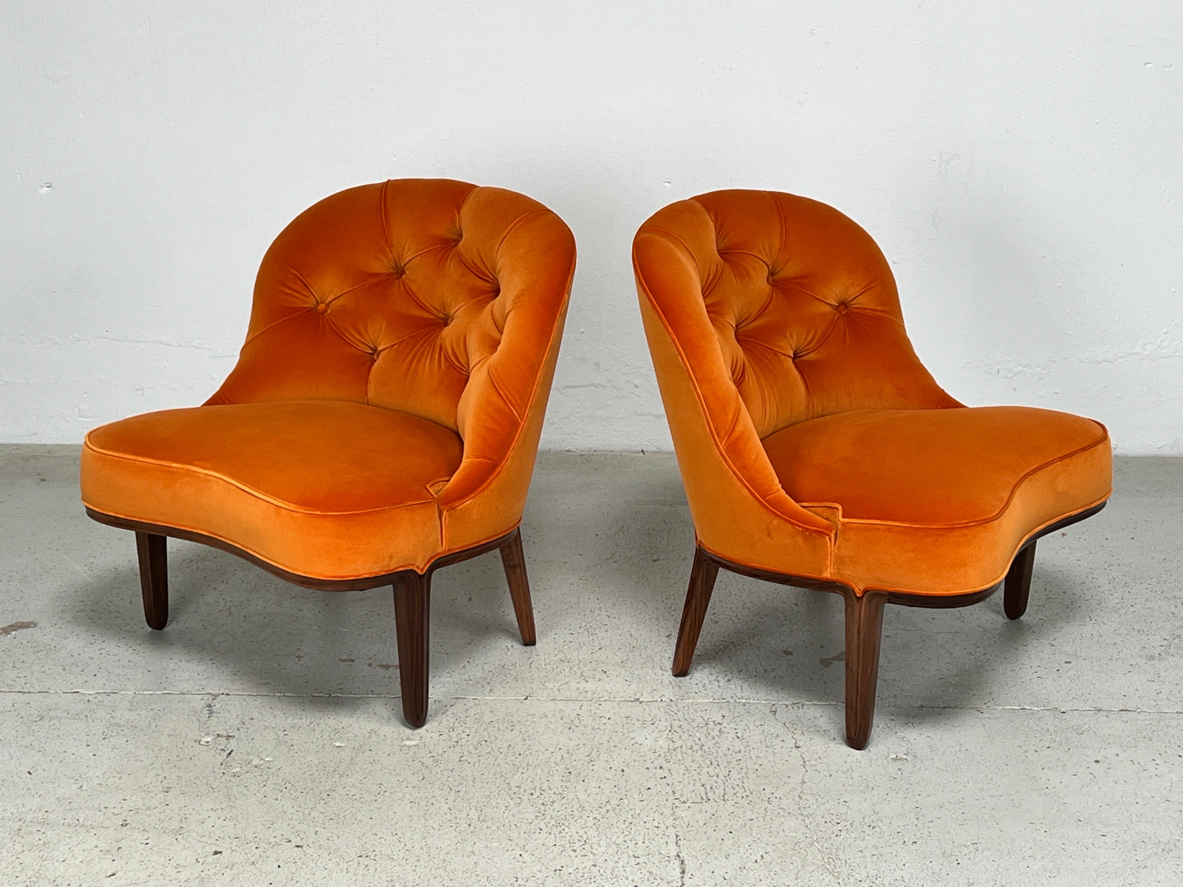 A beautifully restored pair of Janus slipper chairs with walnut frames and orange velvet upholstery. Designed by Edward Wormley for Dunbar.