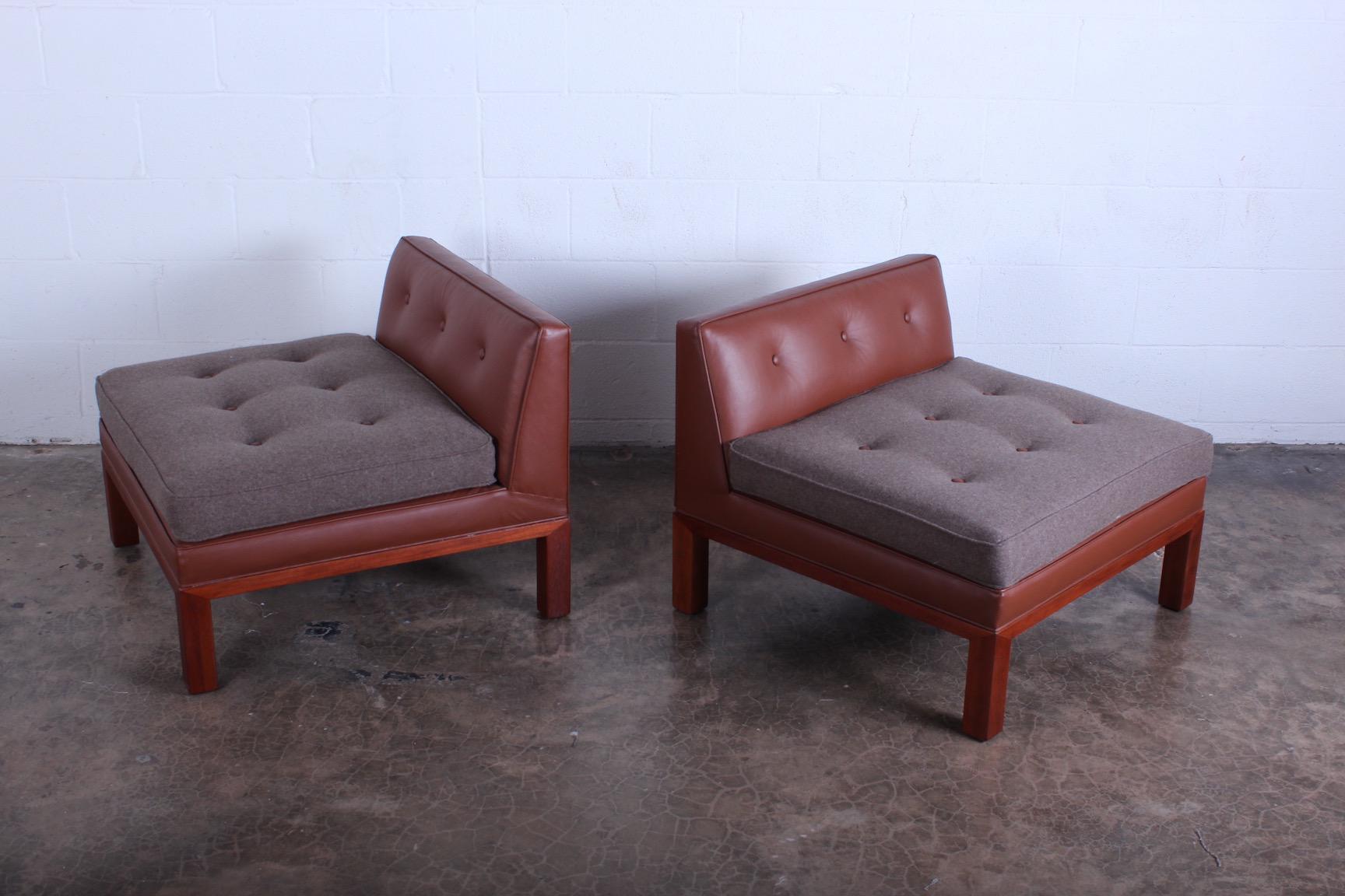 A versatile pair of slipper chairs with mahogany frames and leather/wool upholstery. Designed by Edward Wormley for Dunbar.