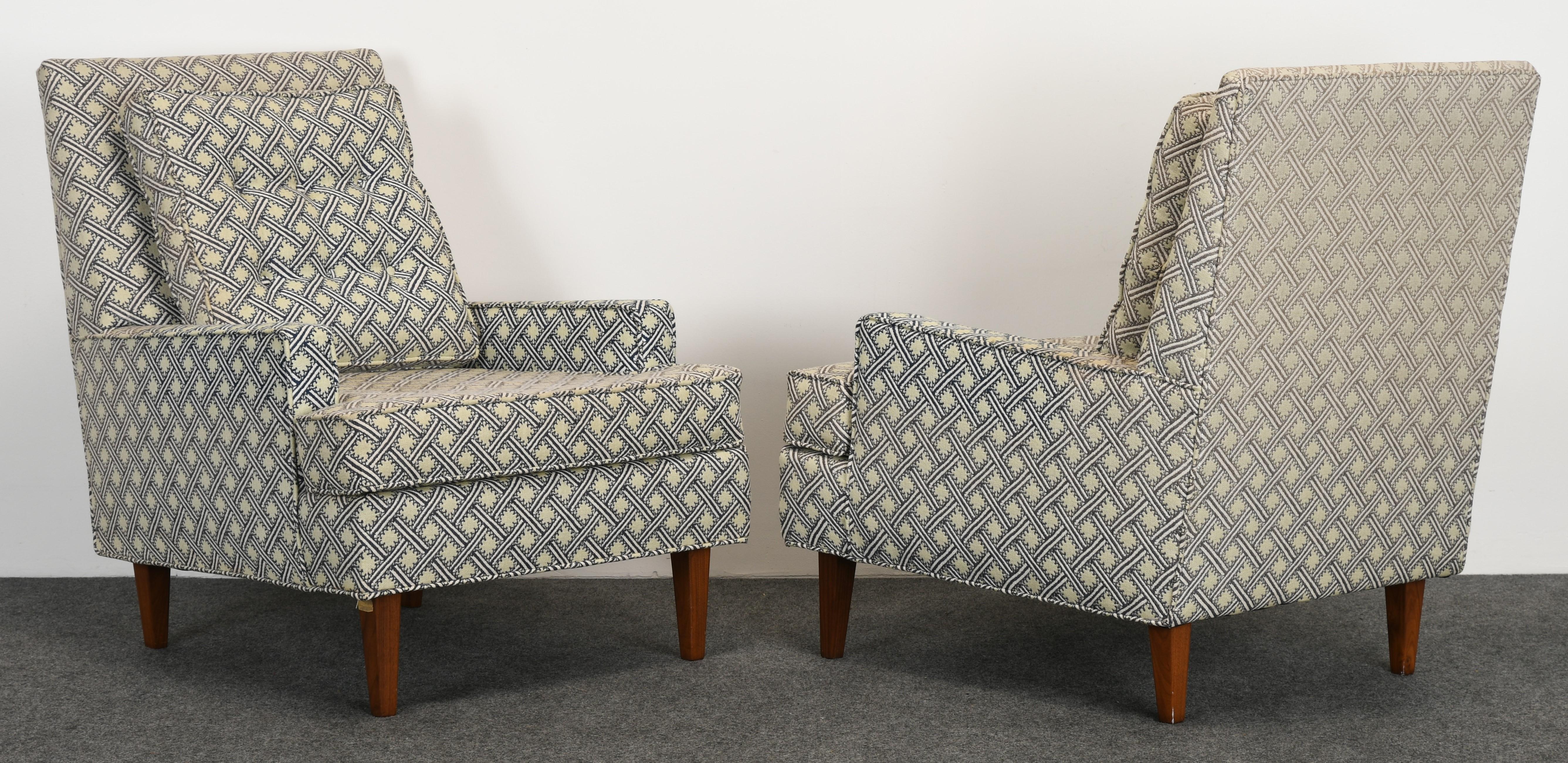A modern pair of stylish armchairs in the manner of Dunbar or Harvey Probber. These lounge chairs have lots of depth to the frame for added comfort. The fabric is faded, new upholstery necessary. The chairs are structurally sound with