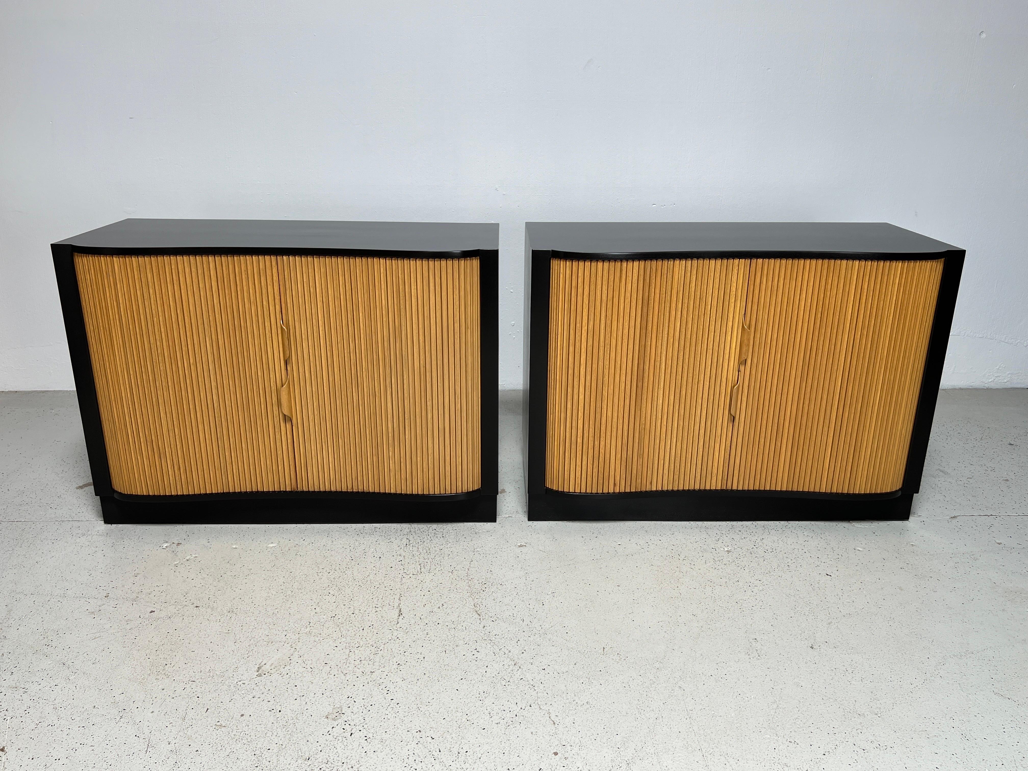 A pair of two toned tambour door serpentine cabinets designed by Edward Wormley for Dunbar.