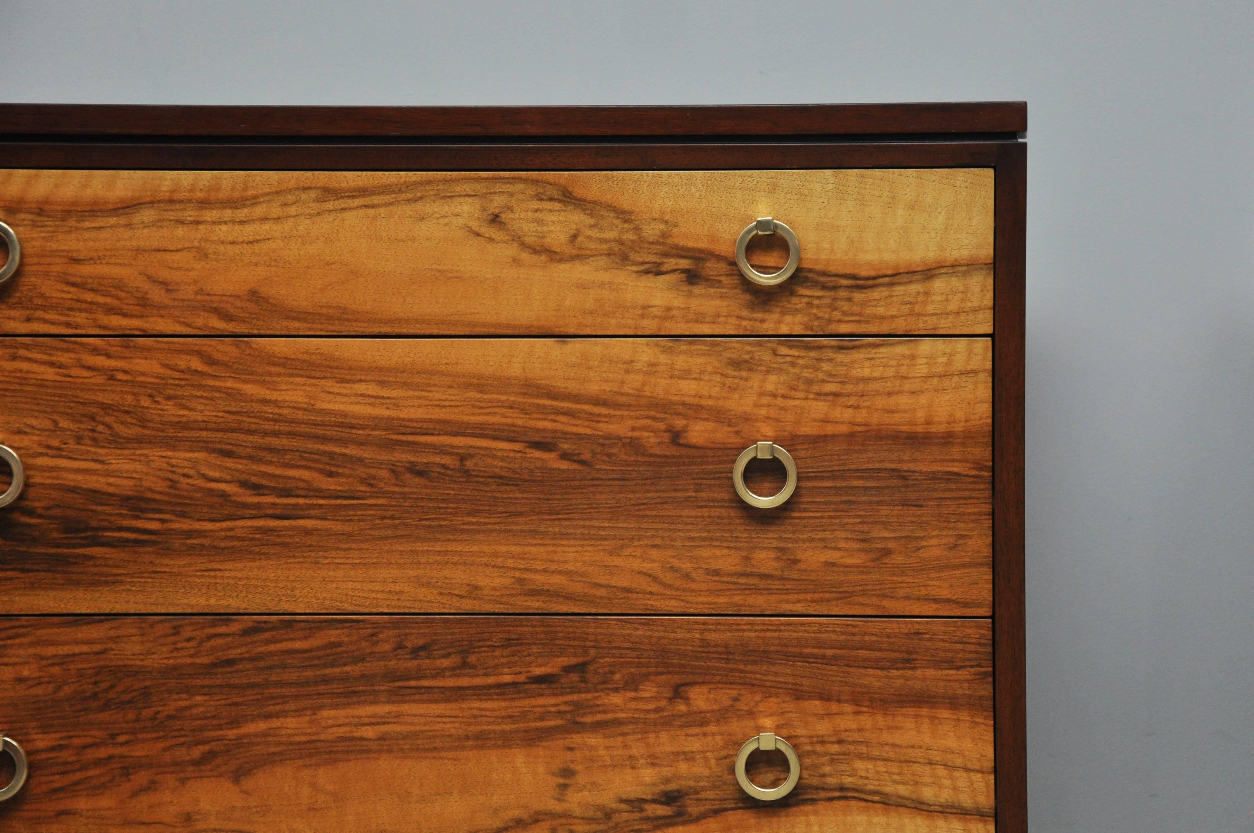Pair of three-drawer chests by Edward Wormley for Dunbar. Model 6422. Fully restored and refinished. Dark walnut cases surround natural walnut drawer fronts with brass ring pulls.