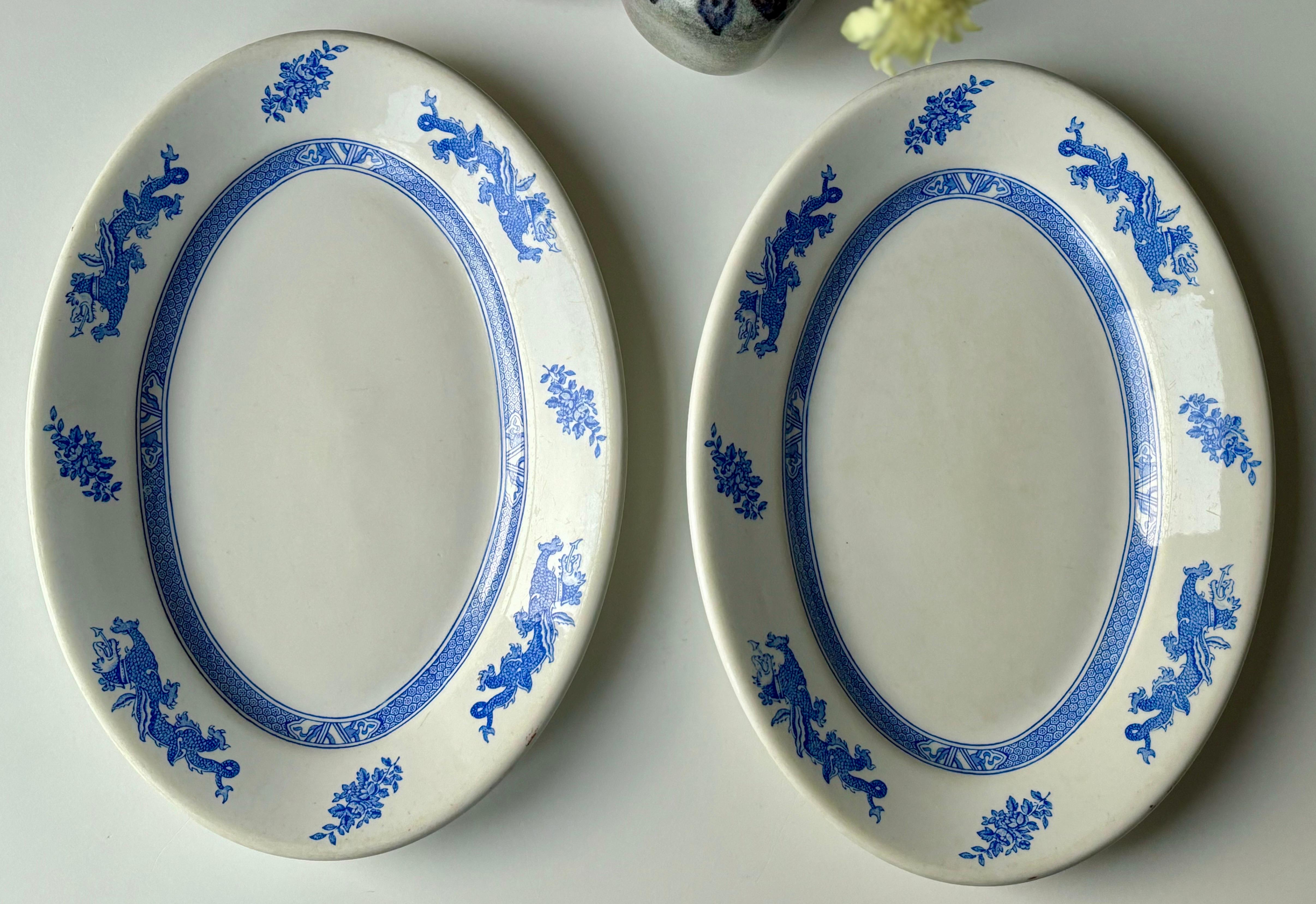 Juego de dos fuentes inglesas de forma ovalada, fabricadas por Dunn Bennett en la década de 1960. Base blanca crema con intrincados adornos de inspiración asiática en azul claro a lo largo de los bordes. Estampado bajo la base. 
Gran estado vintage.