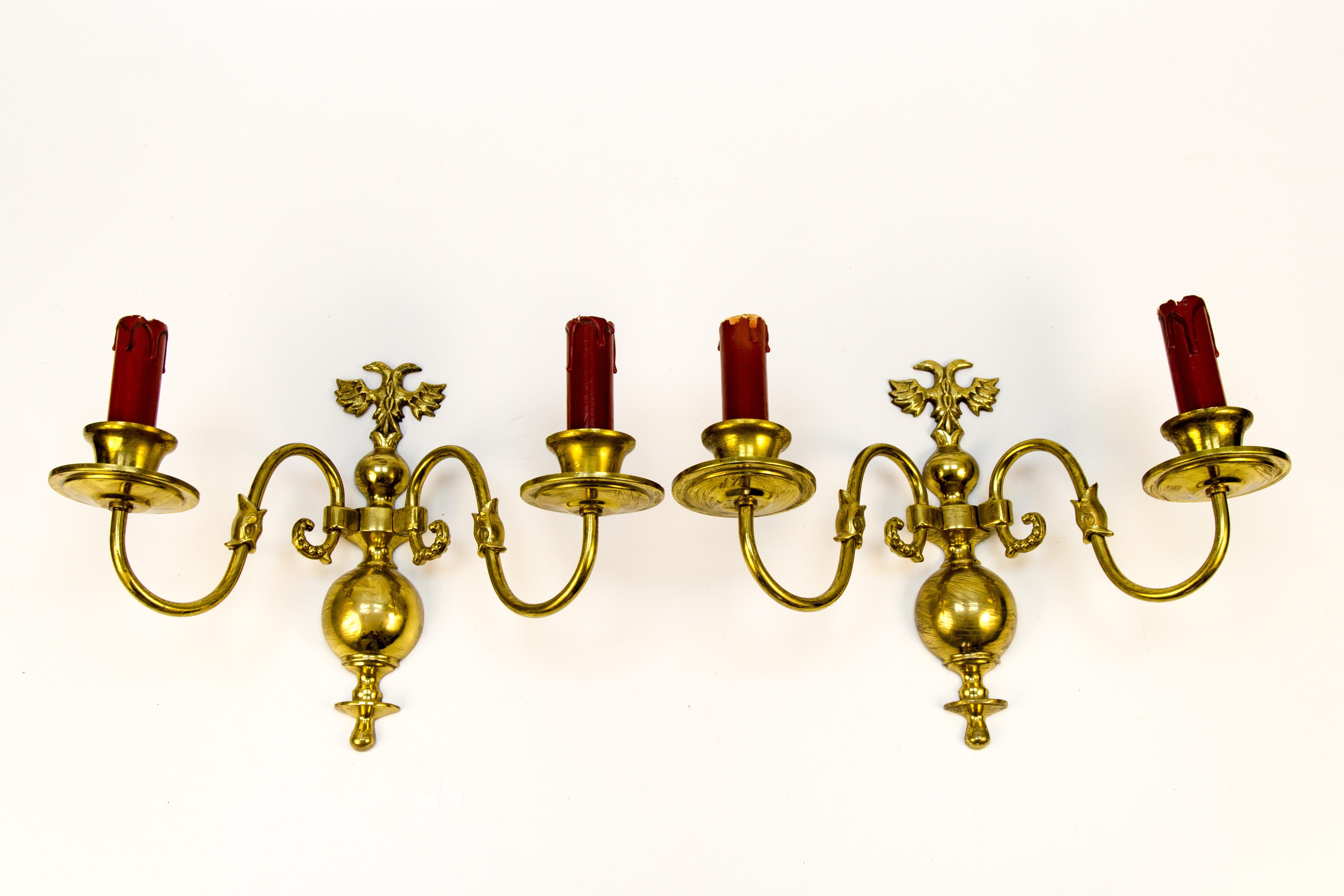 A pair of Dutch brass wall sconces from the 1930s. They each have twin nicely stylized arms depicting fish and serpent with classic candle-style bulb holders.
On the top of the central finial, there is a double-headed eagle and a large baluster or