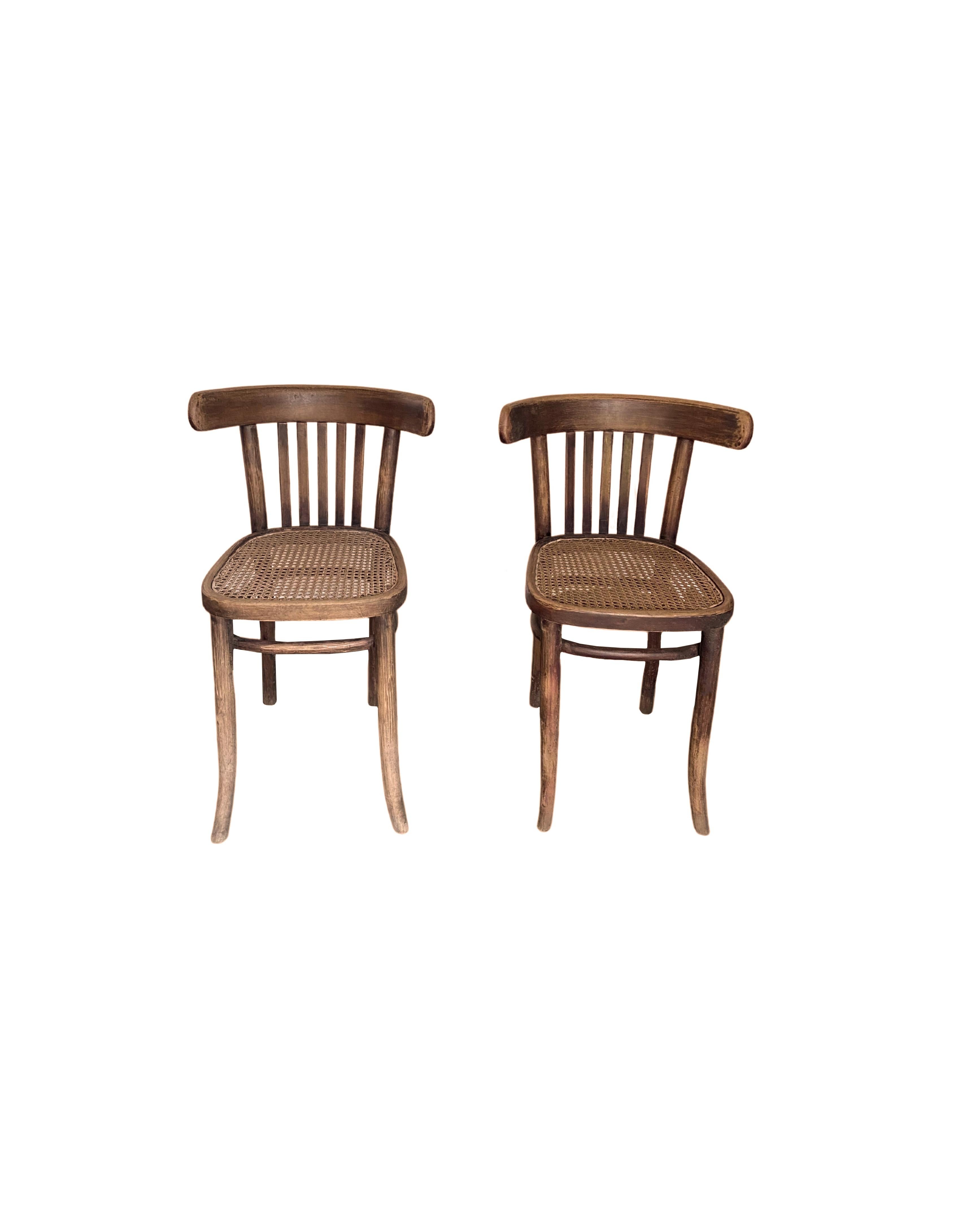 An elegant pair of early 20th Century Dutch colonial chairs with cane seats from Java, Indonesia. Their curved legs, and age related patina of the wood adds to their charm. 

 