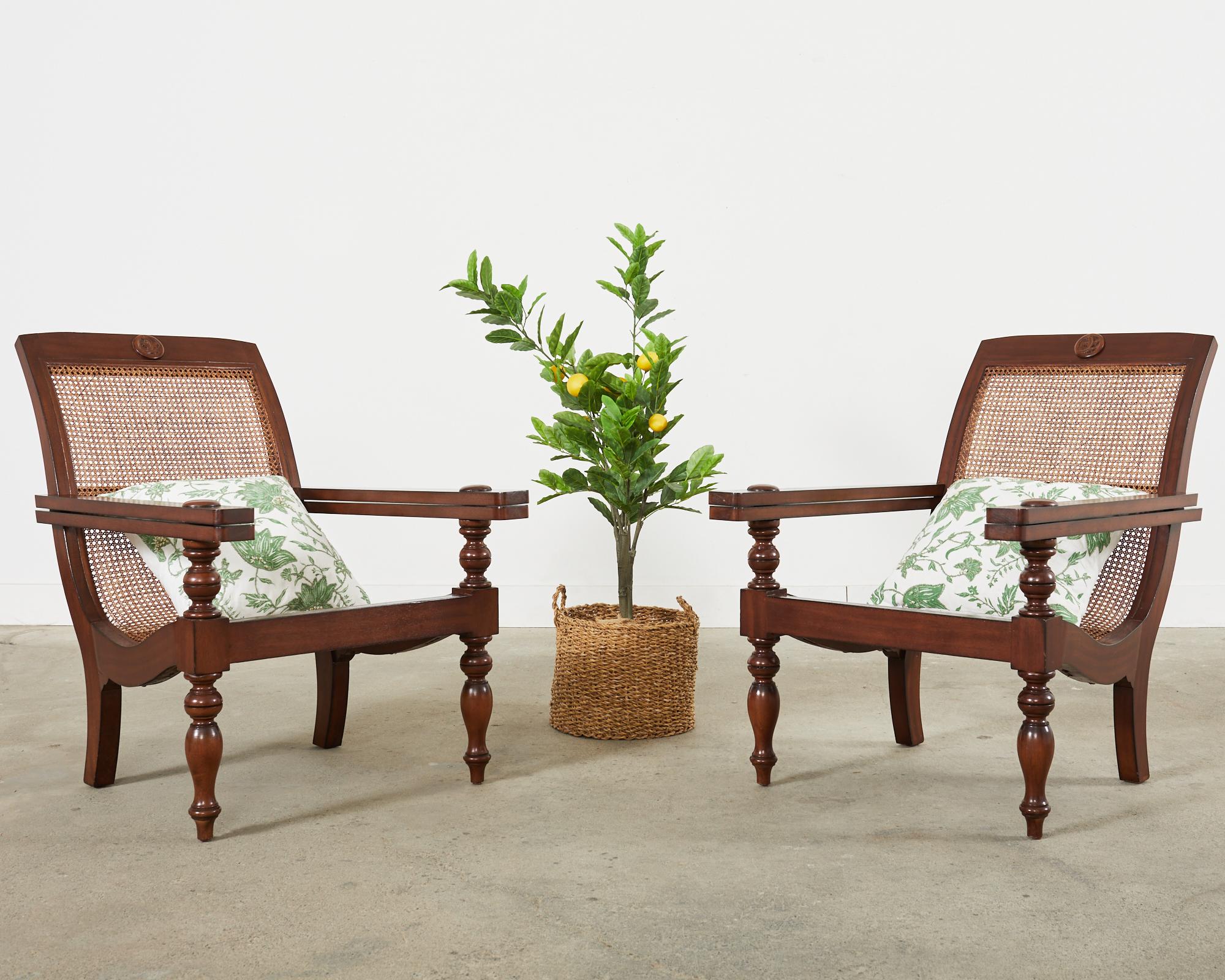 Gorgeous pair of plantation lounge chairs crafted from mahogany in the Dutch colonial manner. The chairs feature an oversized frame inset with woven cane. The gracefully curved frame has long, wide flat arms with extensions for resting the legs. The