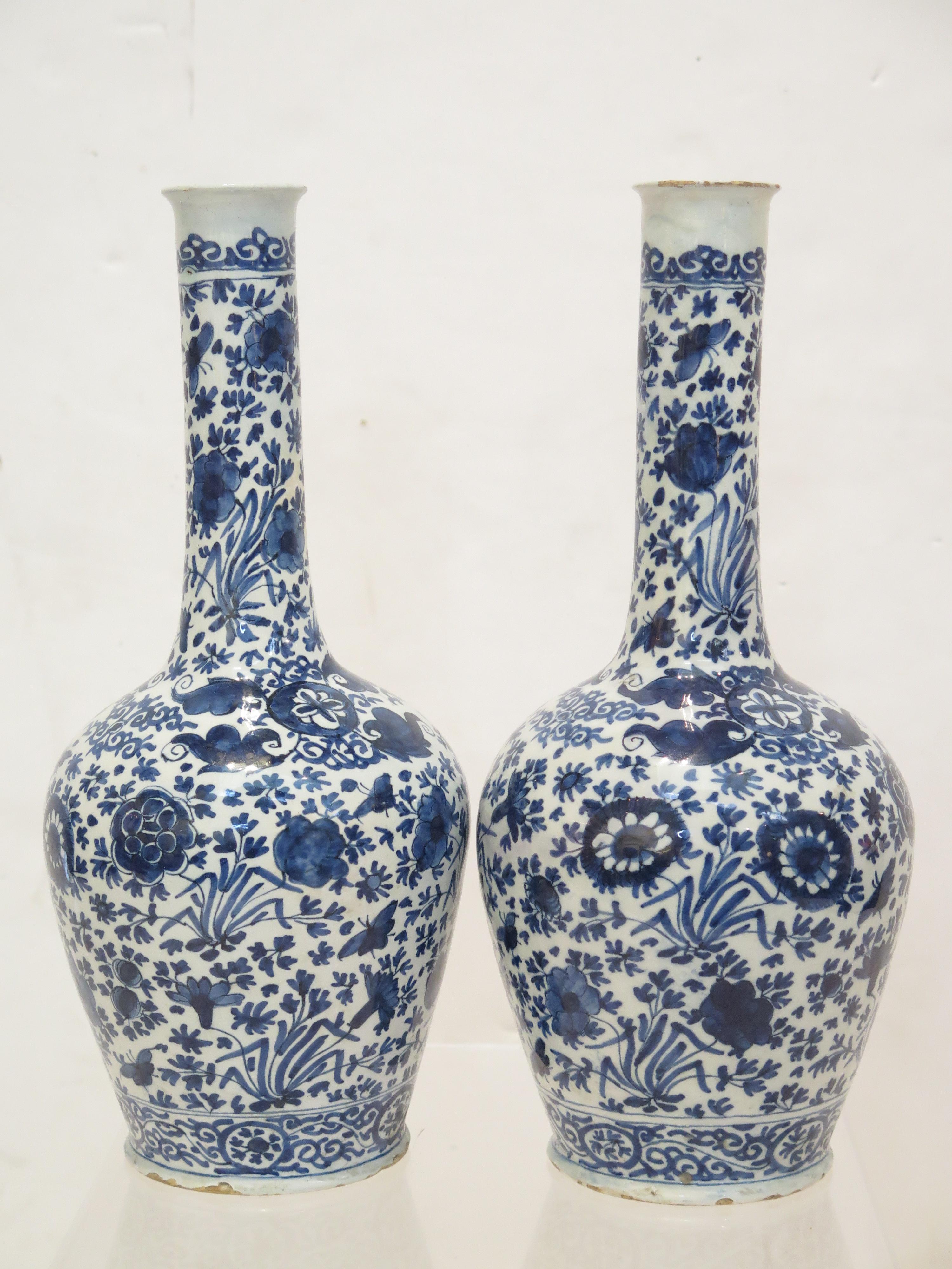 A pair of Dutch Delft blue and white bottle vases decorated in cobalt blue with  bands of scrolling, butterflies, leaves and flowers. 19th Century.

                                                    14