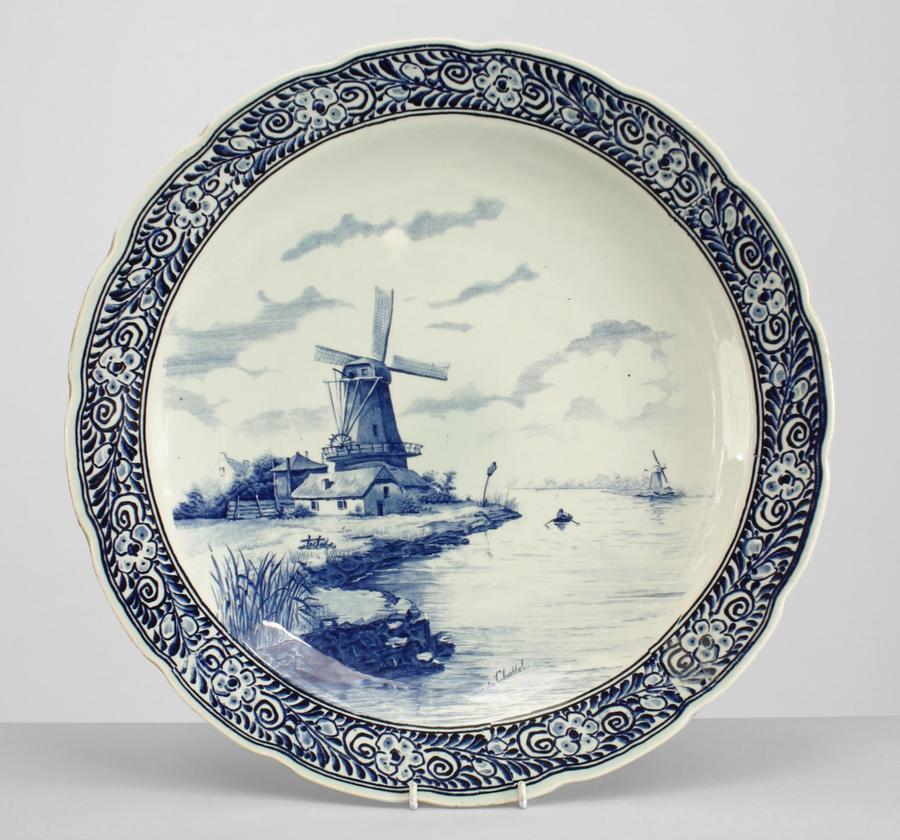 Pair of Dutch blue and white Delft porcelain (19/20th Century) wall plaques with scalloped edge and landscape scene of windmills (one signed noir du Chattel.) (priced as pair).
 