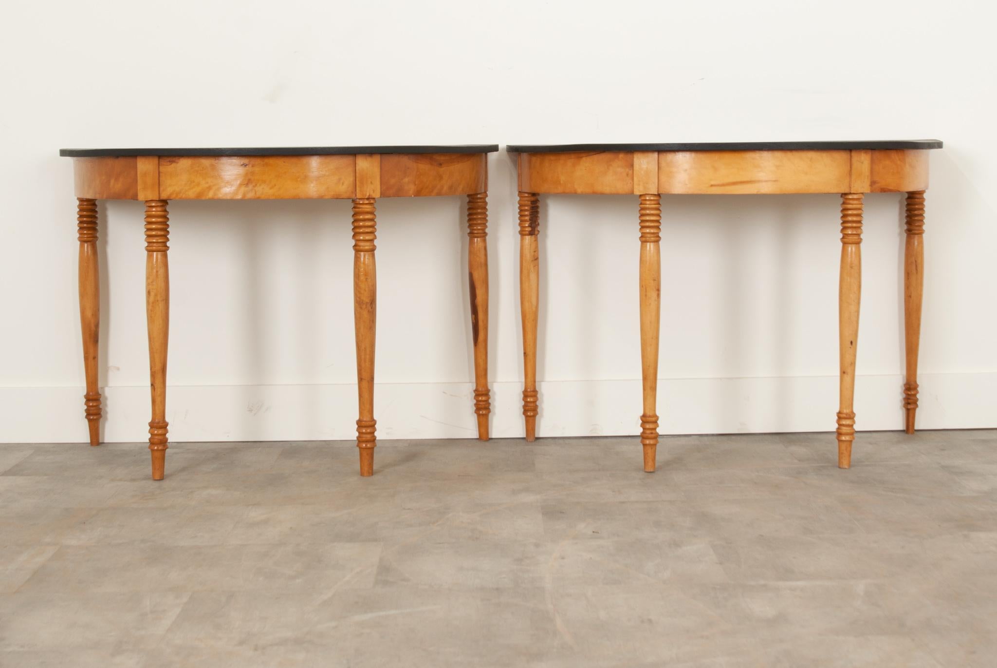 A fantastic pair of Dutch pine and satinwood demi-lune console tables from the 19th century. Their tops have been recently painted matte black, combining a sleek modern element with classic design. Recently cleaned and polished with French wax