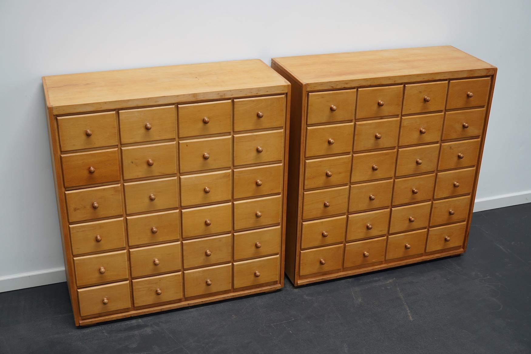 This pair of apothecary cabinets were made circa 1950/60s in the Netherlands. They feature 24 drawers in solid beech with wooden knobs. The interior dimensions of the drawers are: D W H 30 x 15.5 x 11 cm. The cabinets are sold individually.