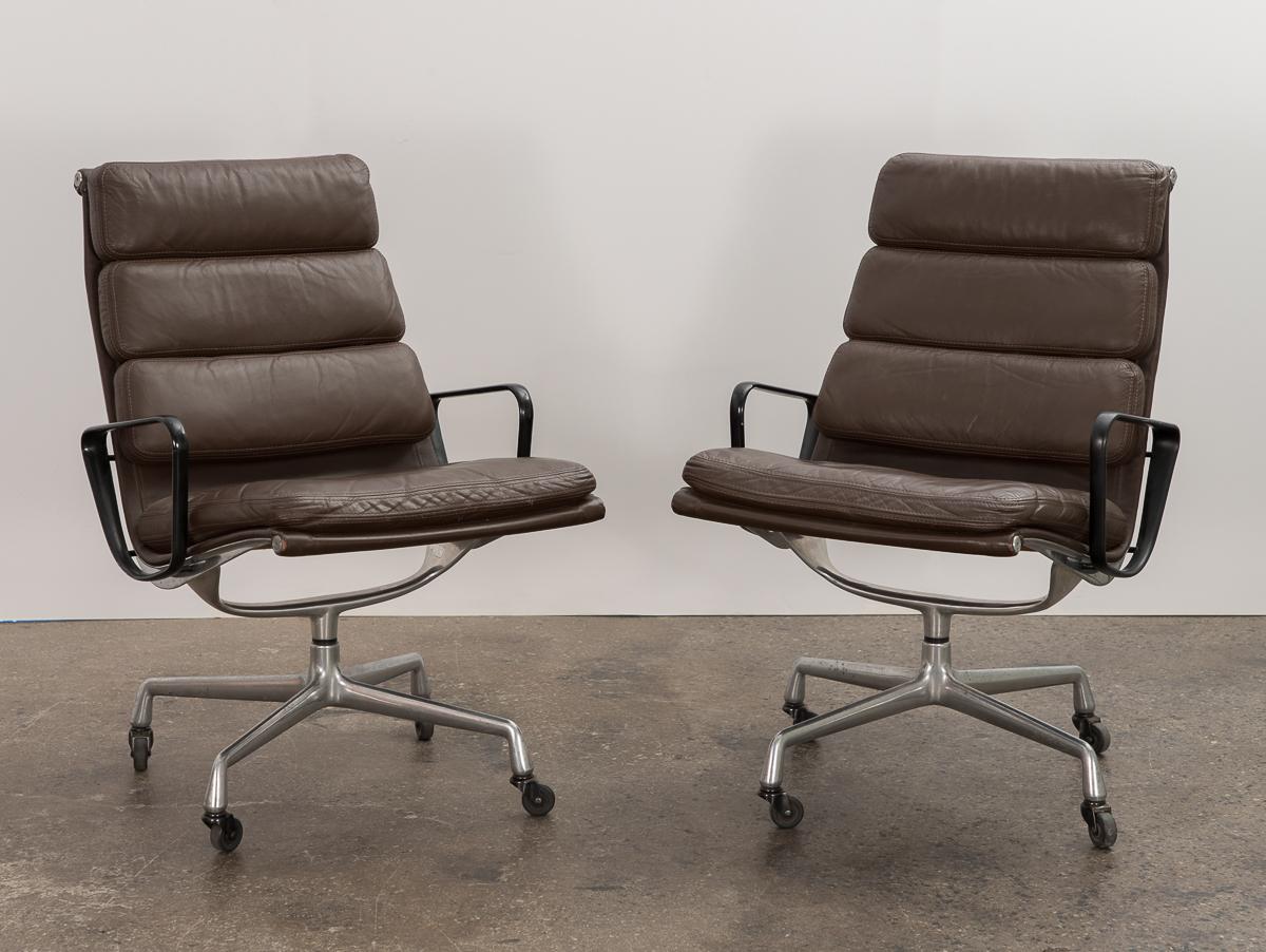Pair of soft pad executive swivel chair on swivel lounge base, designed by Charles and Ray Eames for Herman Miller. Known for their seat cushions, the high back on this version enhances the comfort level. Soft, pliable dark brown leather is in good