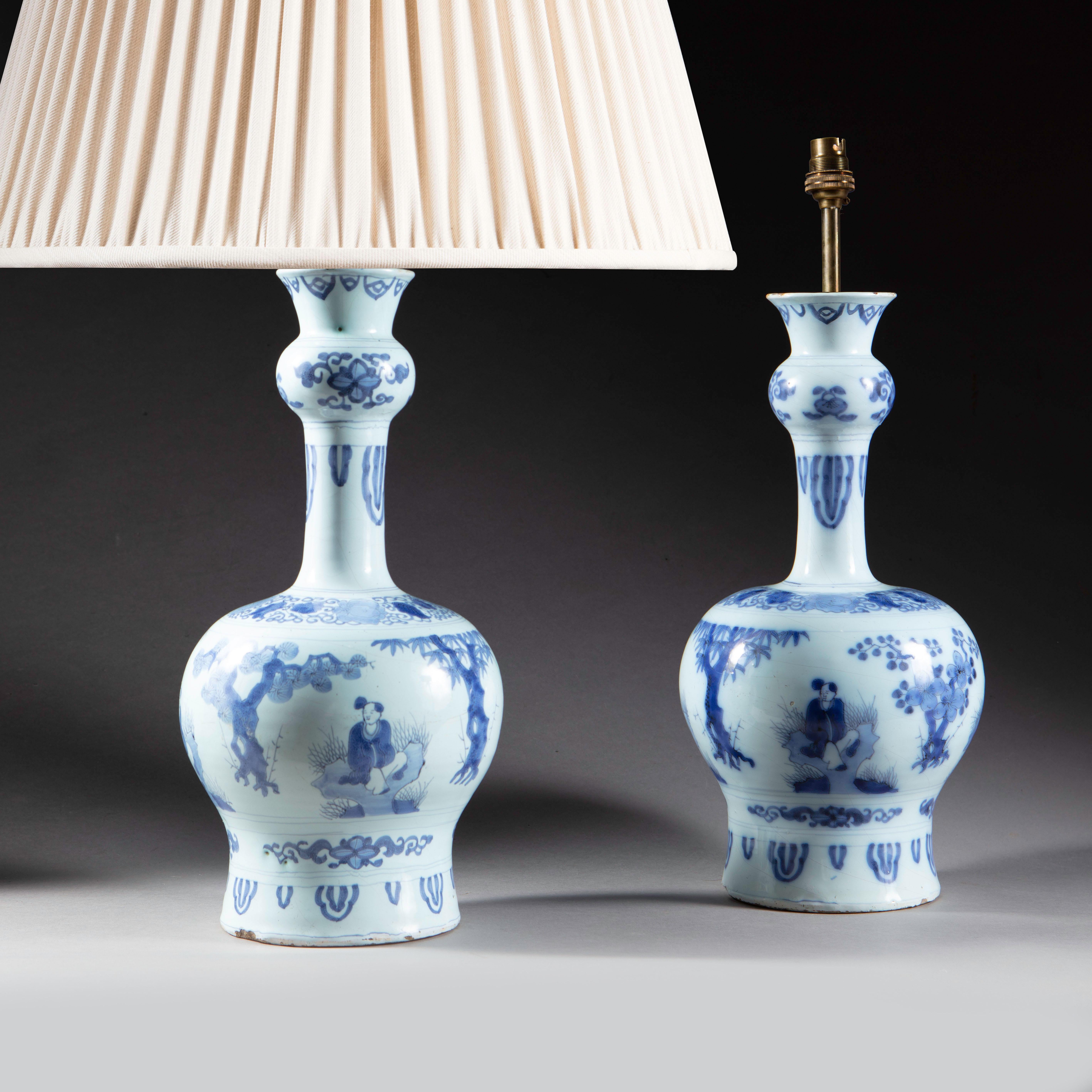 A charming pair of early 18th century Dutch Delft blue and white knobble vases decorated with repeating seated Chinese figures interspersed with trees possibly representing the Four Seasons Willow, Peach, and two ornamental Prunice trees. 
The