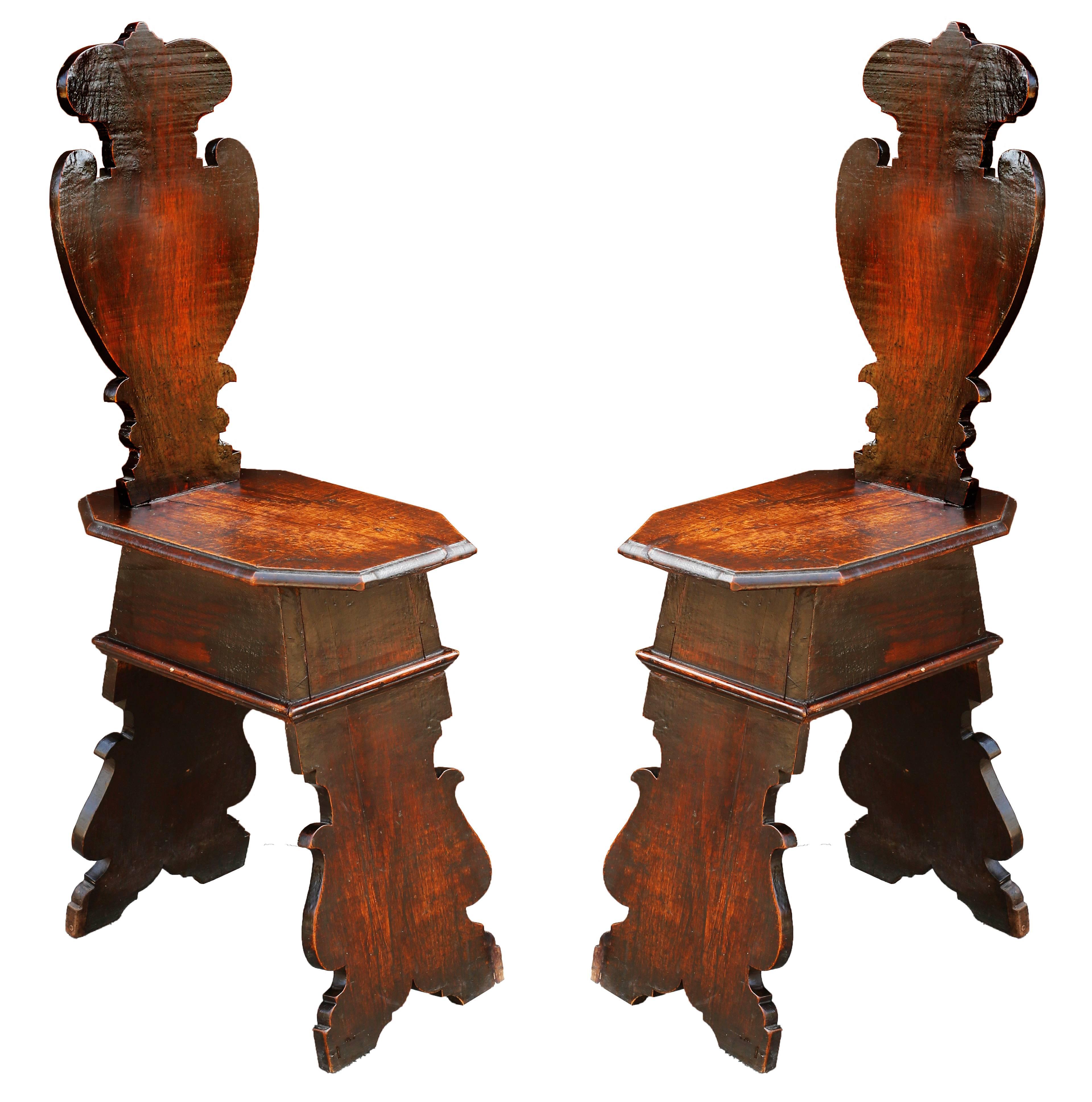 Remarquable paire de chaises de salle en chêne et en noyer d'après les modèles de la Renaissance italienne qui ont été adaptés par les Anglais au début du XVIIIe siècle. Cette forme de tabouret décoratif était simplement constituée de planches, mais