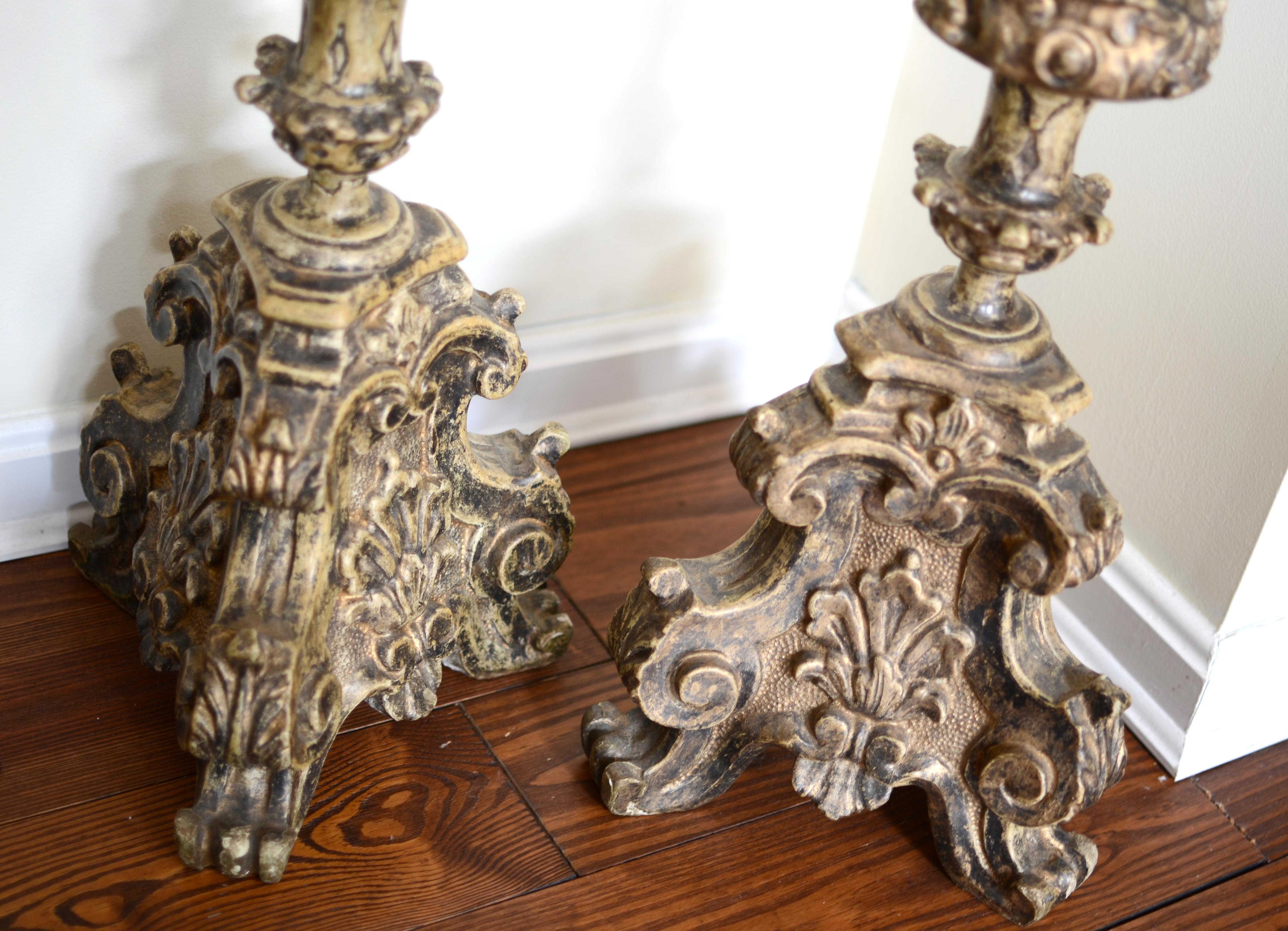 A pair of antique decorative plaster and wood Italian candelabras.

Italy; early 18th century style, possibly made in the 19th century
Approximate size: 81 cm (h) each

A pair of elaborately realized candelabras in carved-wood with traces of