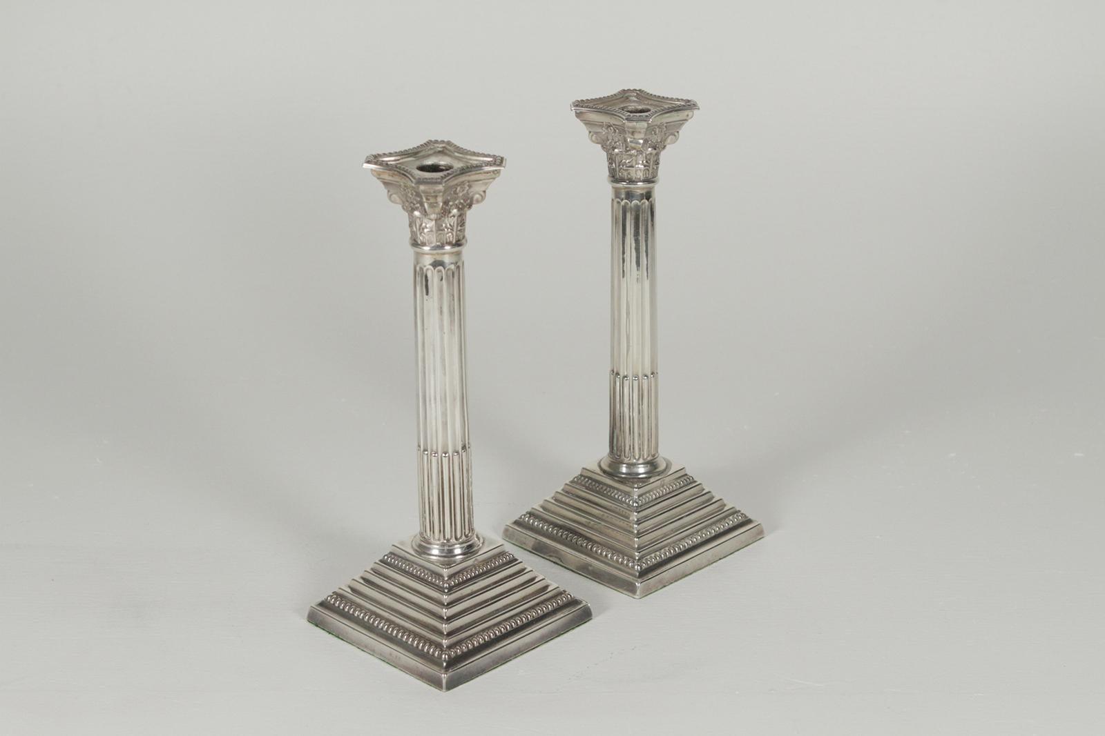 Pair of early 1900s English sterling silver column motif candlesticks. The neoclassical form with original bobeches. A full 12