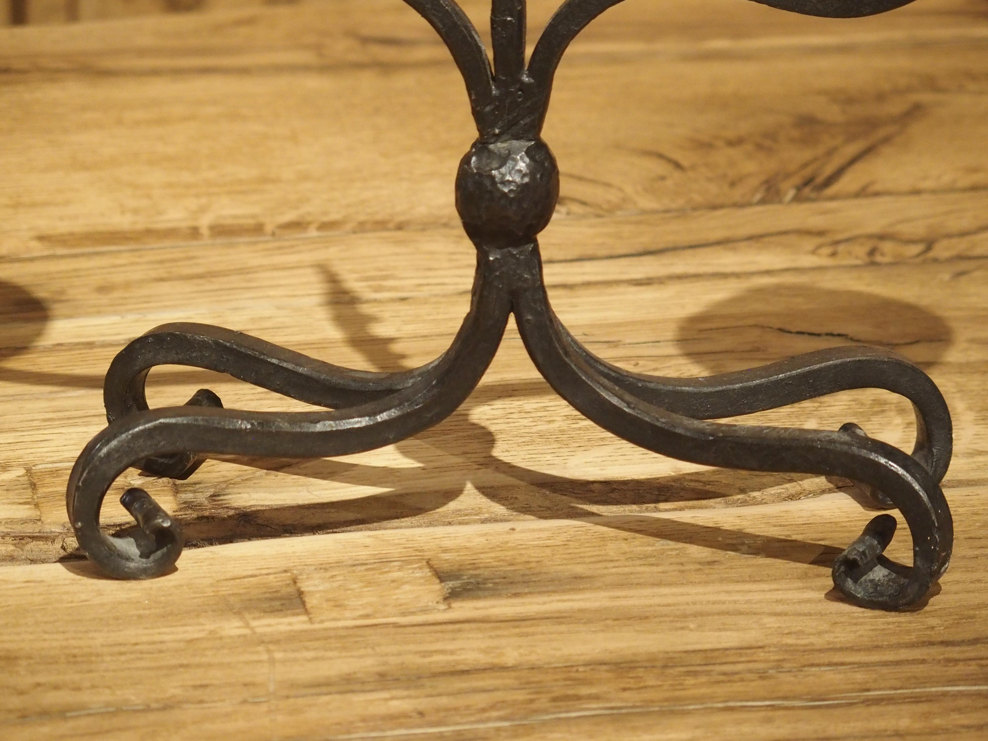 This pair of forged iron candleholders was produced in France in the early 1900’s. The two holders have slightly different dimensions, indicating that they were crafted by hand.

Each candleholder has two flat saucer-shaped bobeches beneath