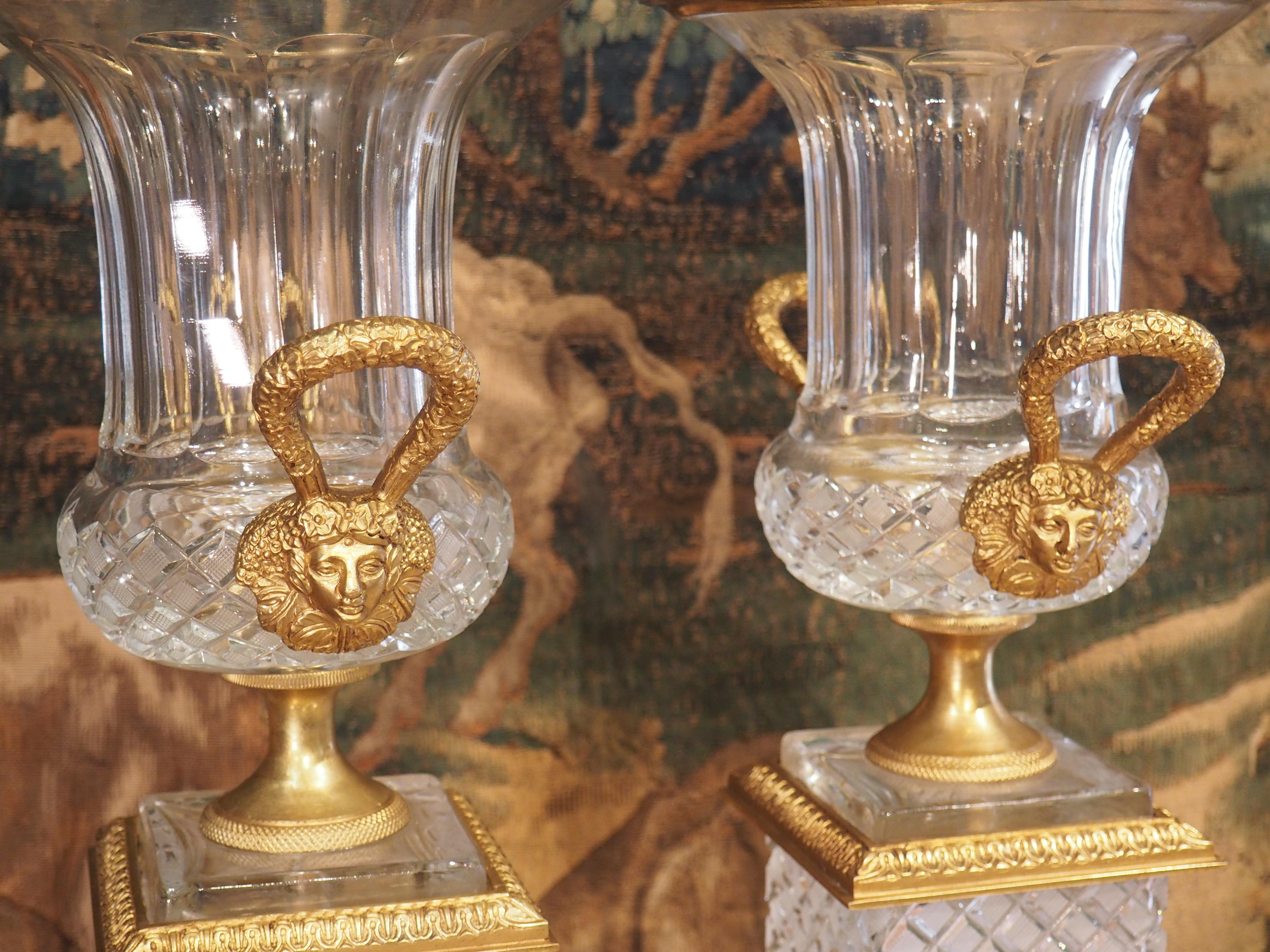 This beautiful pair of glass and gilt bronze vases was produced in France in the early 1900’s and have an overall height of over 20 inches. The calyx krater vases are made of cut glass embellished with gadrooned necks and lozenge patterned bodies.