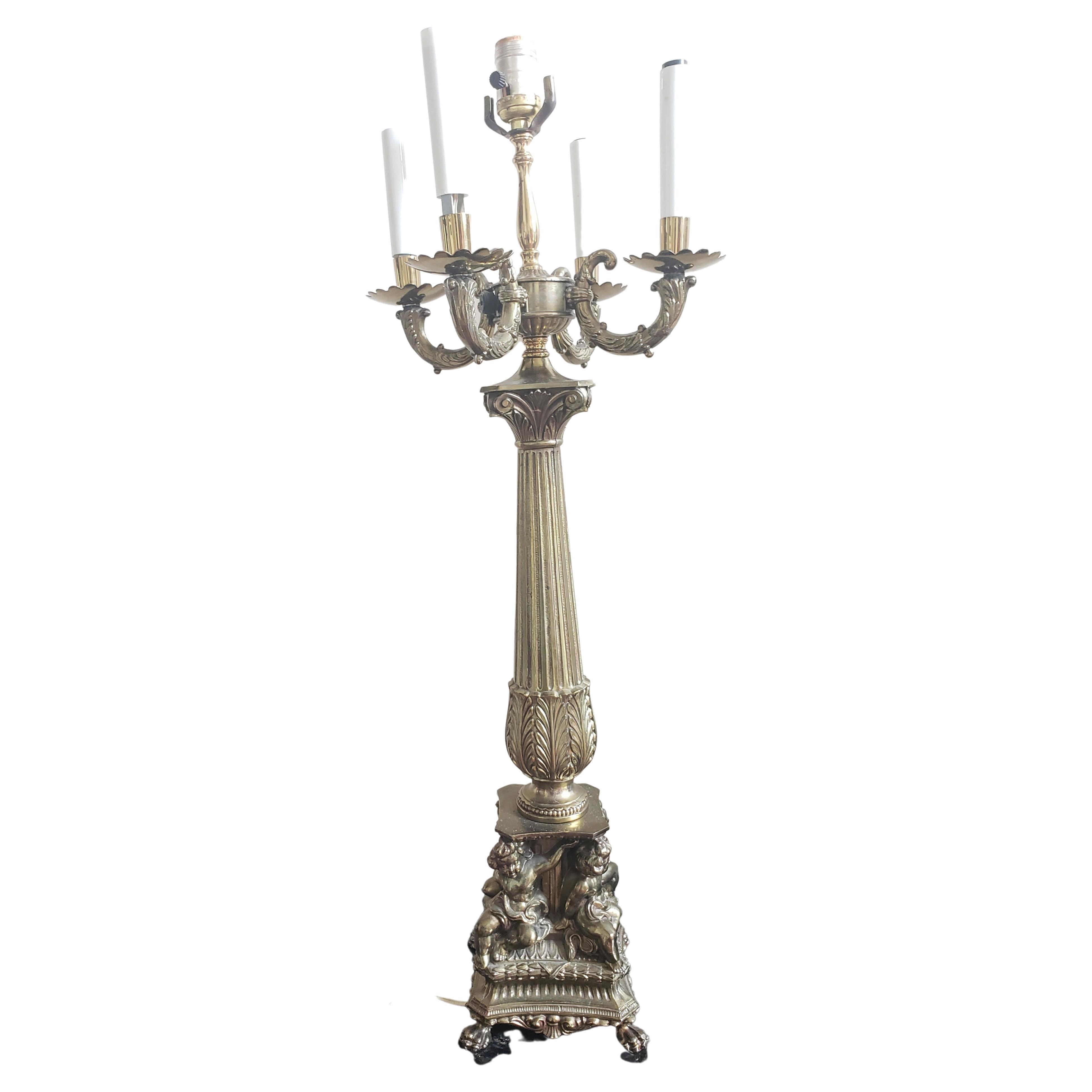 An impressive Pair of Early 1900s French Gilt Spelter Cherub 5-light column Table Lamps. 
Column base on 4 paw feet under  4 cherubs, a cannelure body. Measures 6.5 inches square base. and stands 32 inches tall to the top of the center main lamp