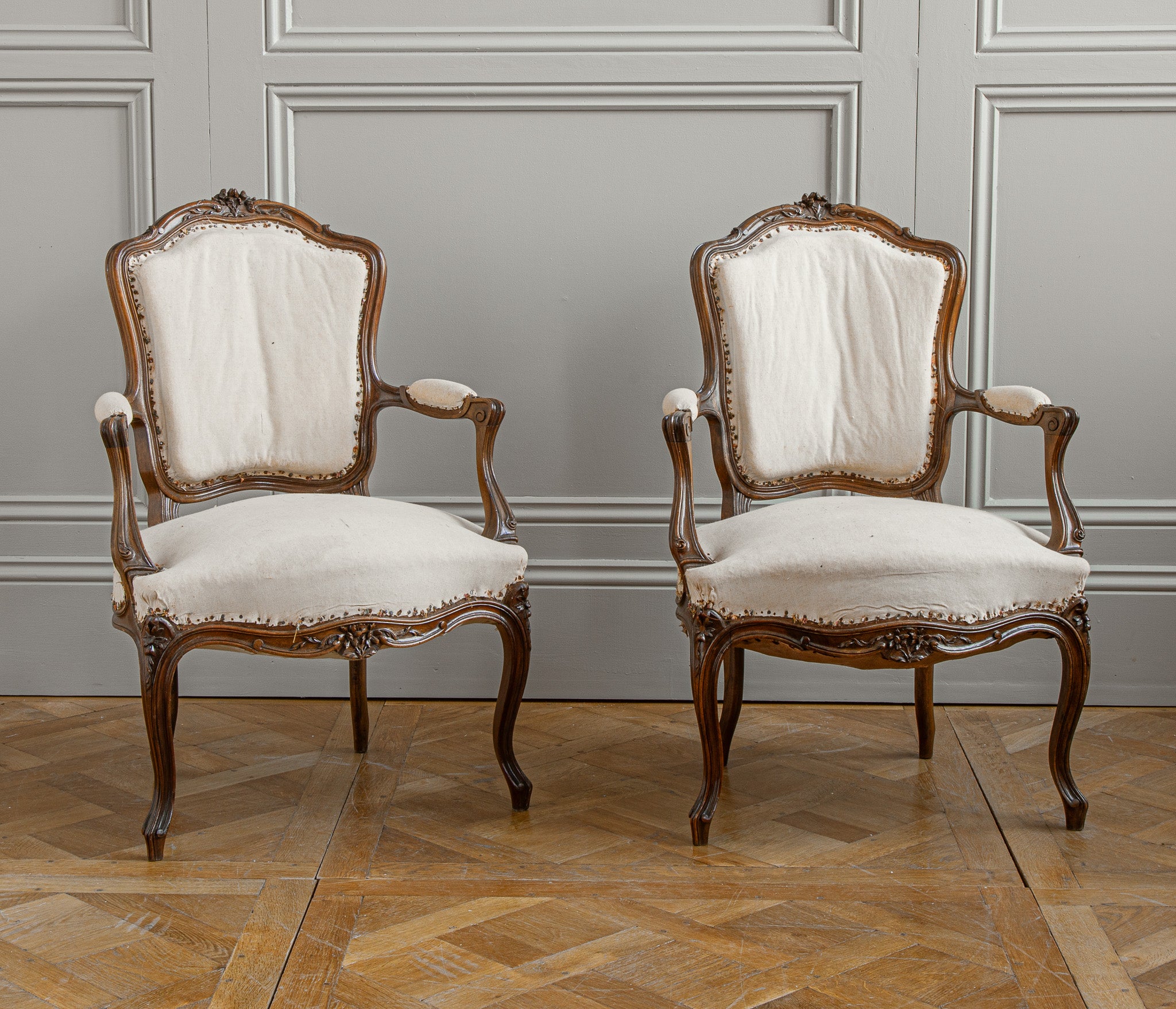 A pair of Louis XV style hand-carved solid walnut Armchairs circa early 1900's, from France.
The chairs have some pretty detailing in the fine carving on the chairs featuring small flowers. 
We offer upholstery on request with a large selection of