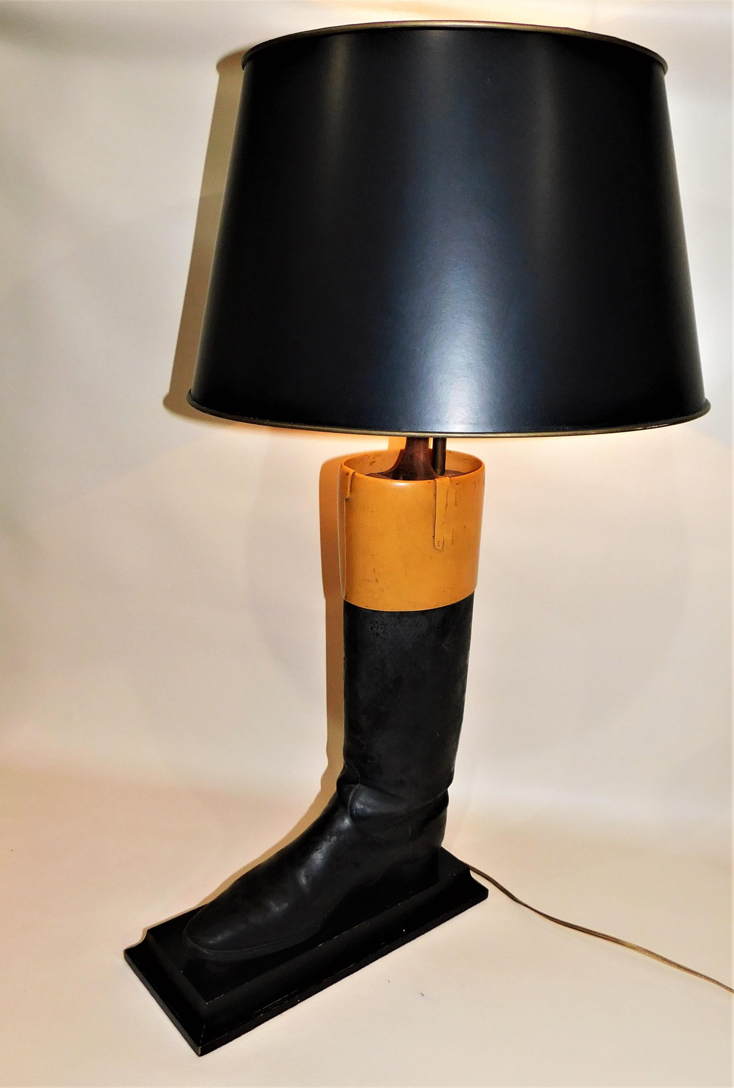 Vintage pair of unique leather hunting or riding boot lights and there original boot trees/molds mounted on a wood base and wired as table lamps. Both in working condition, two black shades and finials included. The top of the boot is a harder