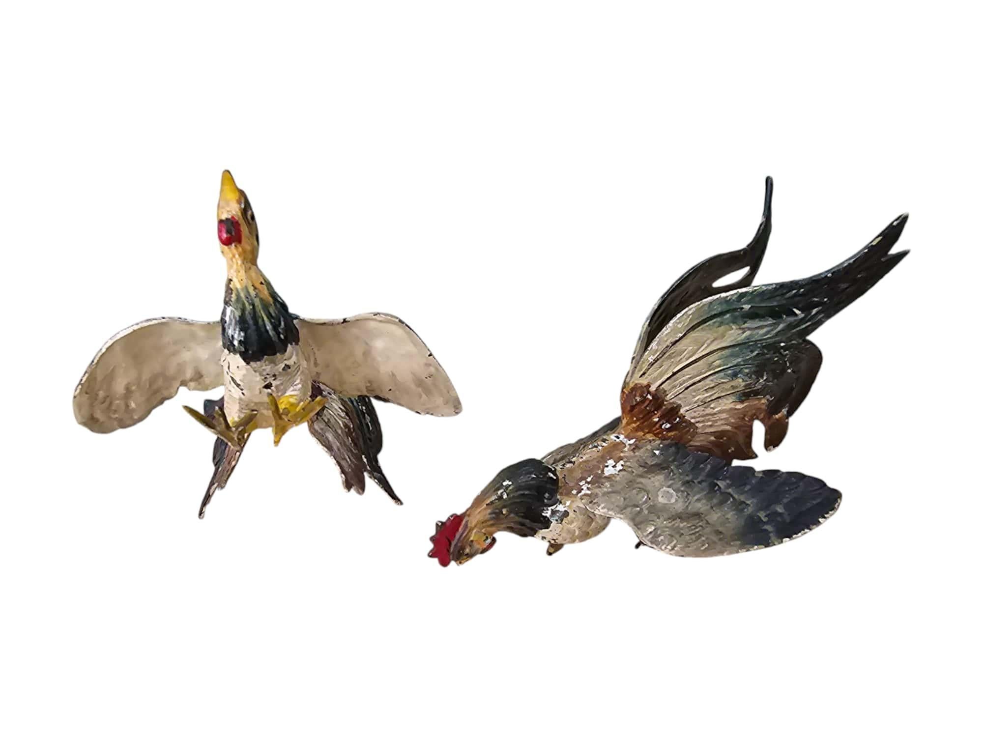 Add a touch of vintage charm to your decor with this delightful pair of painted metal rooster figurines from the early 1900s. Each rooster showcases intricate craftsmanship and vibrant colors, making them a charming addition to any collection or