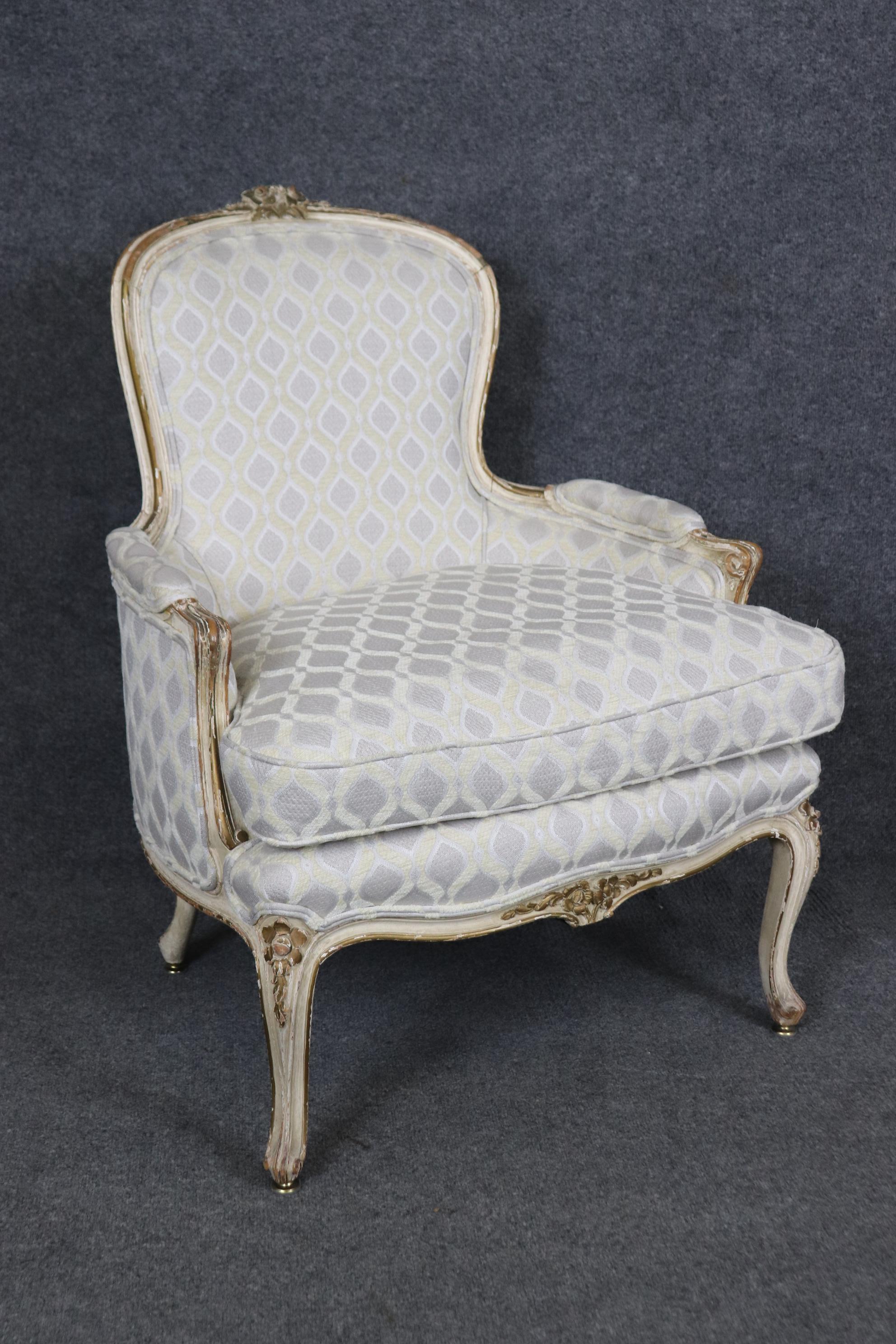 This is superb pair of bergere chairs made in France from the late 1890-1900s era. The chairs are in their original distressed painted and gilded finish and have normal age-related signs of wear and use and patina. The chairs have beautiful