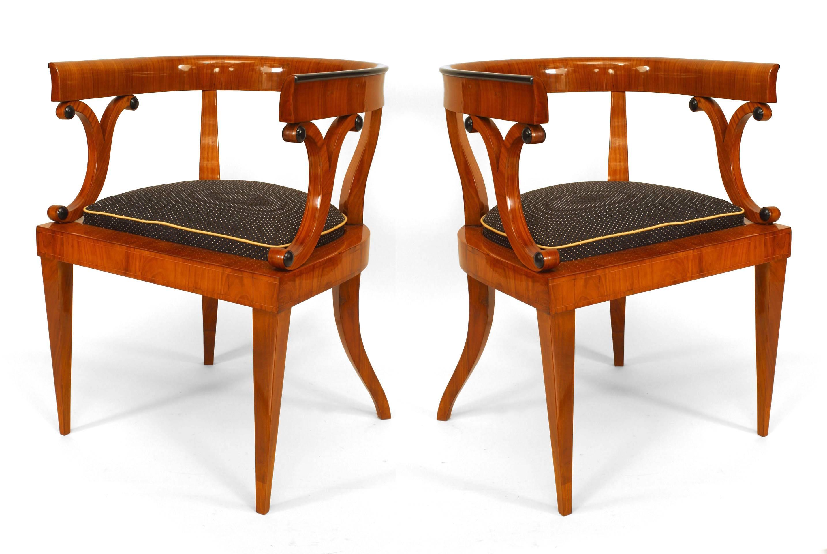 Pair of Austrian Biedermeier (1830s) cherry veneer armchairs with round back design and maple inlay & ebonized details with an inset upholstered seat.
