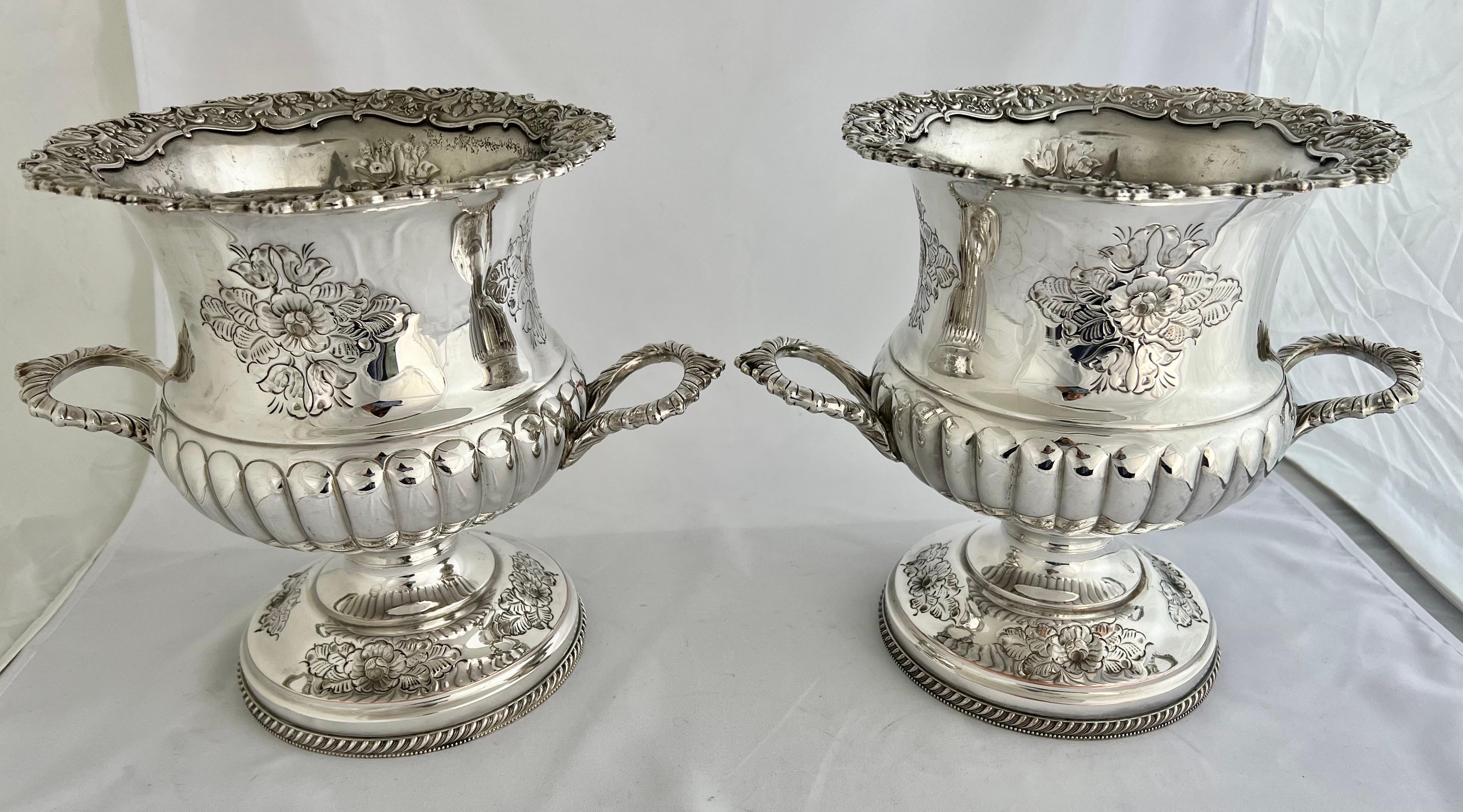 Paire de rafraîchisseurs à vin anglais Sheffield du début du 19e siècle, avec des motifs ciselés à la main.  Les quatre côtés de ces urnes sont ornés de bouquets de fleurs. Cette paire est extrêmement précoce et est restée en très bon état au fil