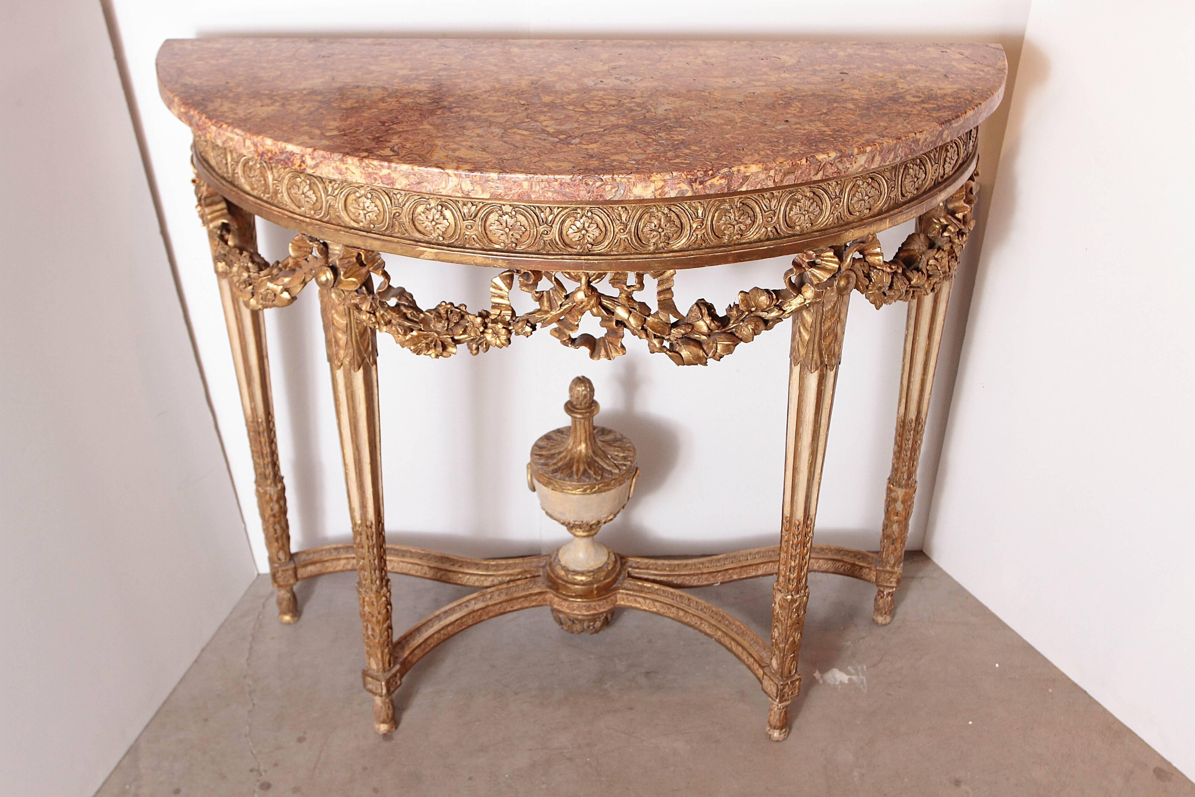 Pair of French Louis XVI gilt carved and cream painted Louis XVI marble top consoles .Gilt carved swag detail with leaves and floral designs.