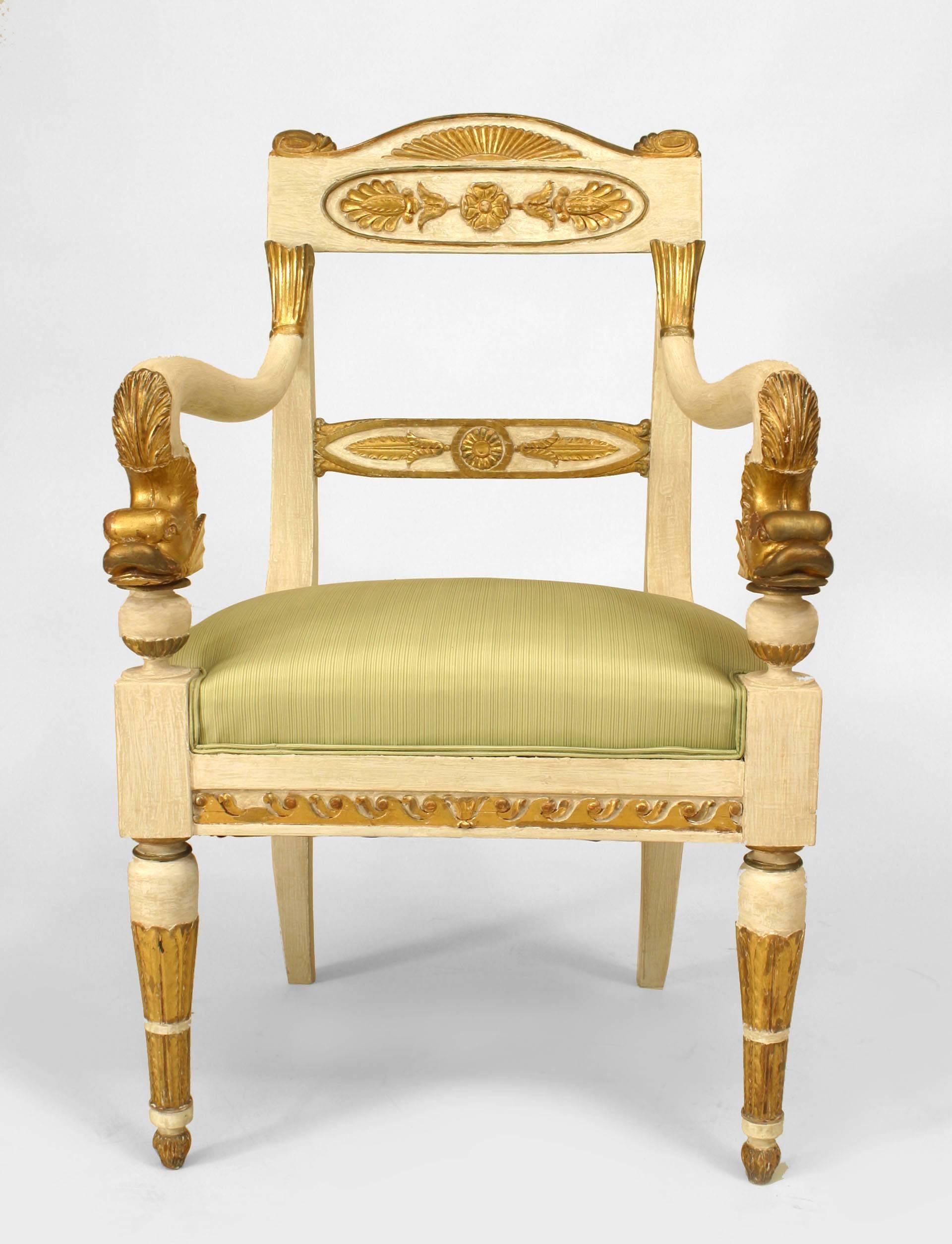 Dating to the first quarter of the nineteenth century, this pair of painted Italian Neoclassic arm chairs features seats upholstered in lime green fabric in addition to decorative gilt carving and trim, most notably prominent dolphin-form arms.