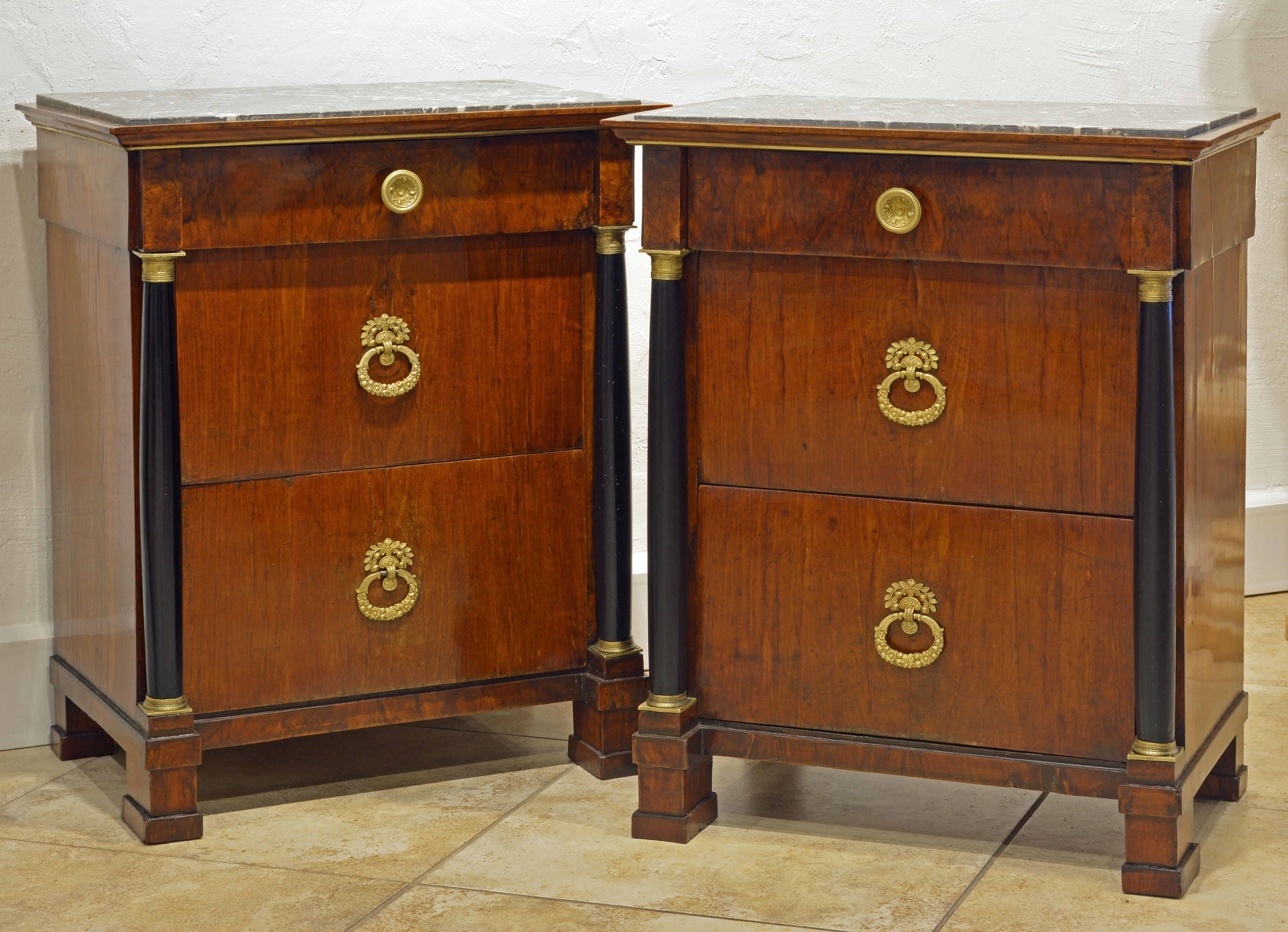 Fashioned in the French Empire style and of that period these Italian commodes feature recessed marble tops above a frieze drawer and two deep drawers flanked by ebonized gilt bronze mounted classical columns.
