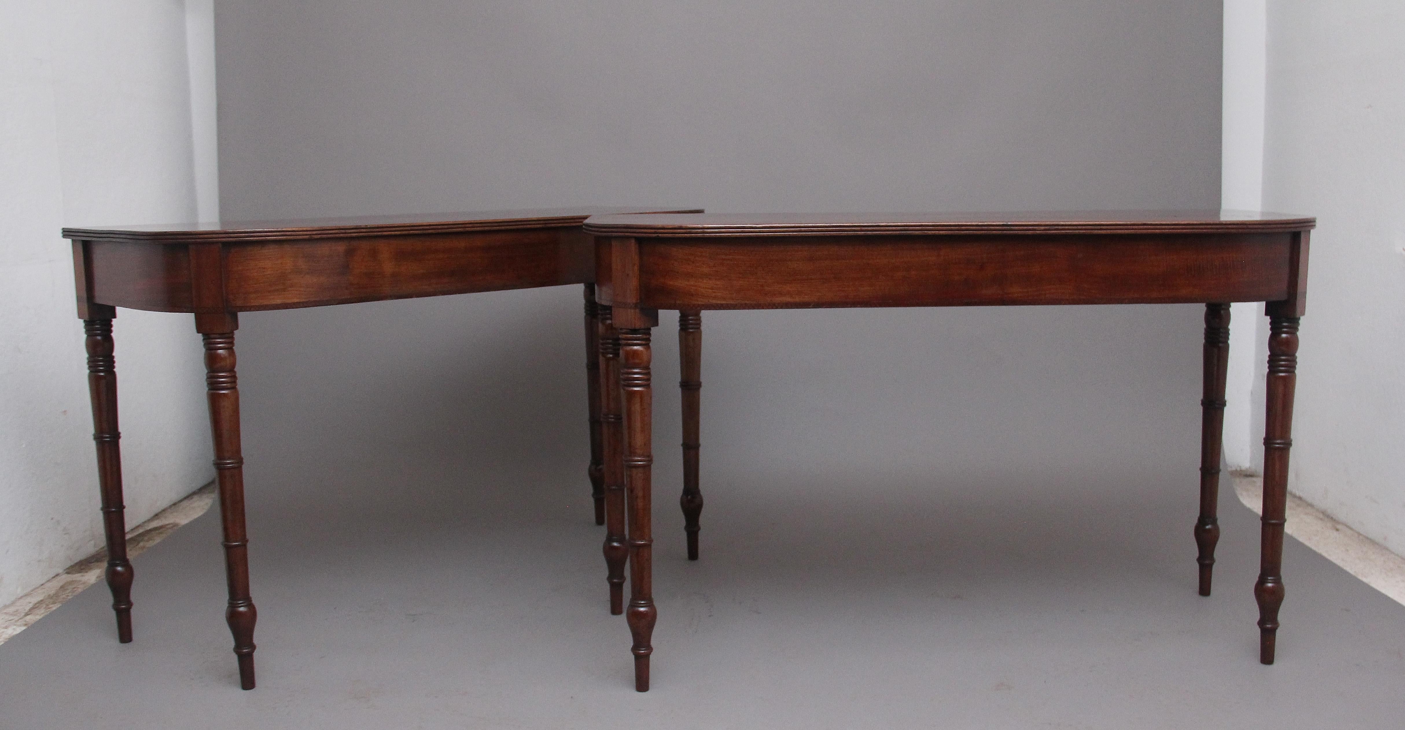 A pair of early 19th Century mahogany console tables, having wonderfully figured D end tops with a reeded edge, inlaid frieze below and supported on elegant turned legs. In excellent condition and having a nice warm rich mahogany colour. Circa 1830.