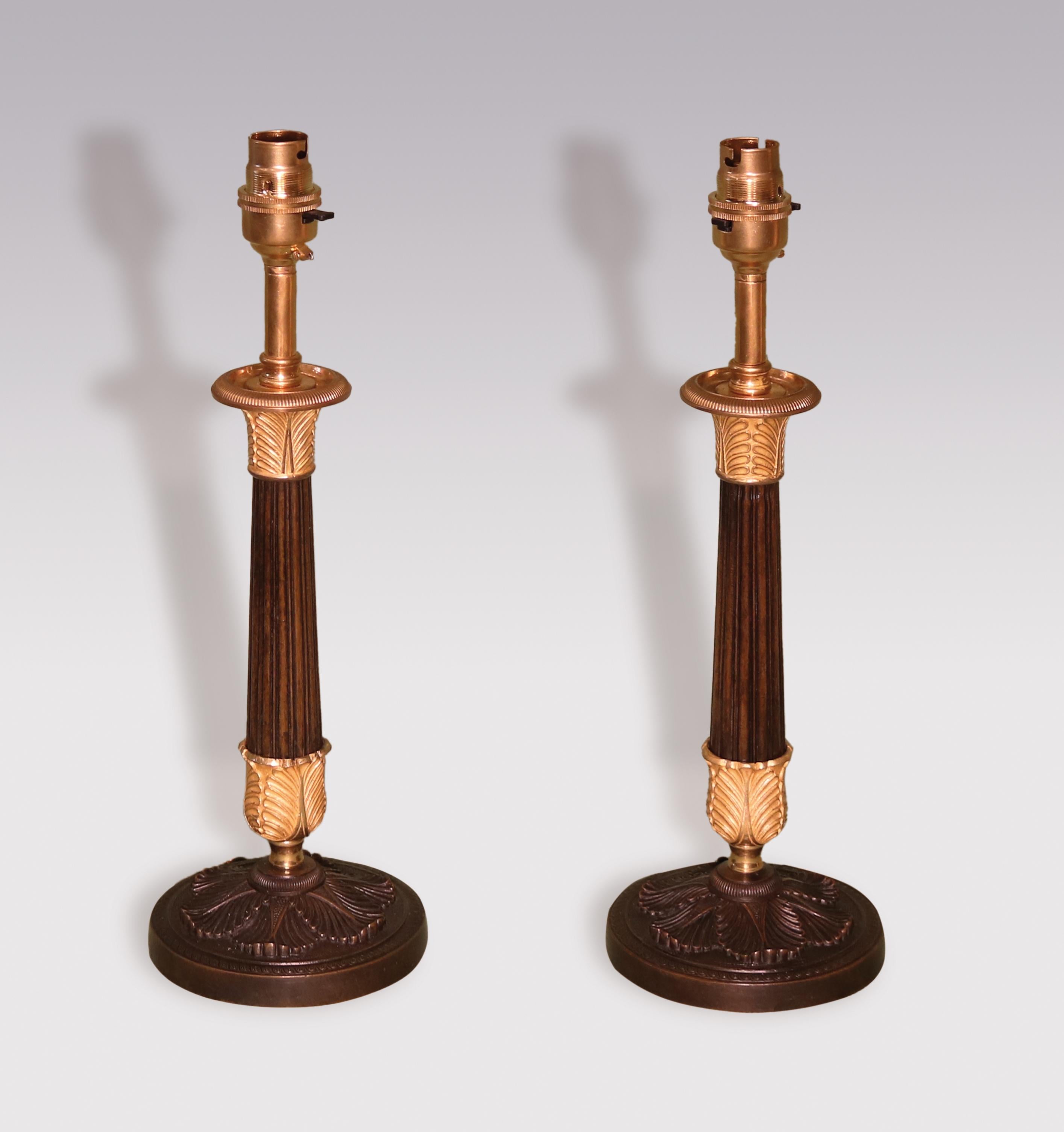 A pair of early 19th century bronze & ormolu candlesticks, having acanthus leaf sconces above reeded tapering stems supported on well-cast acanthus leaf circular bases. (Now converted to lamps)
Height of candlesticks 10