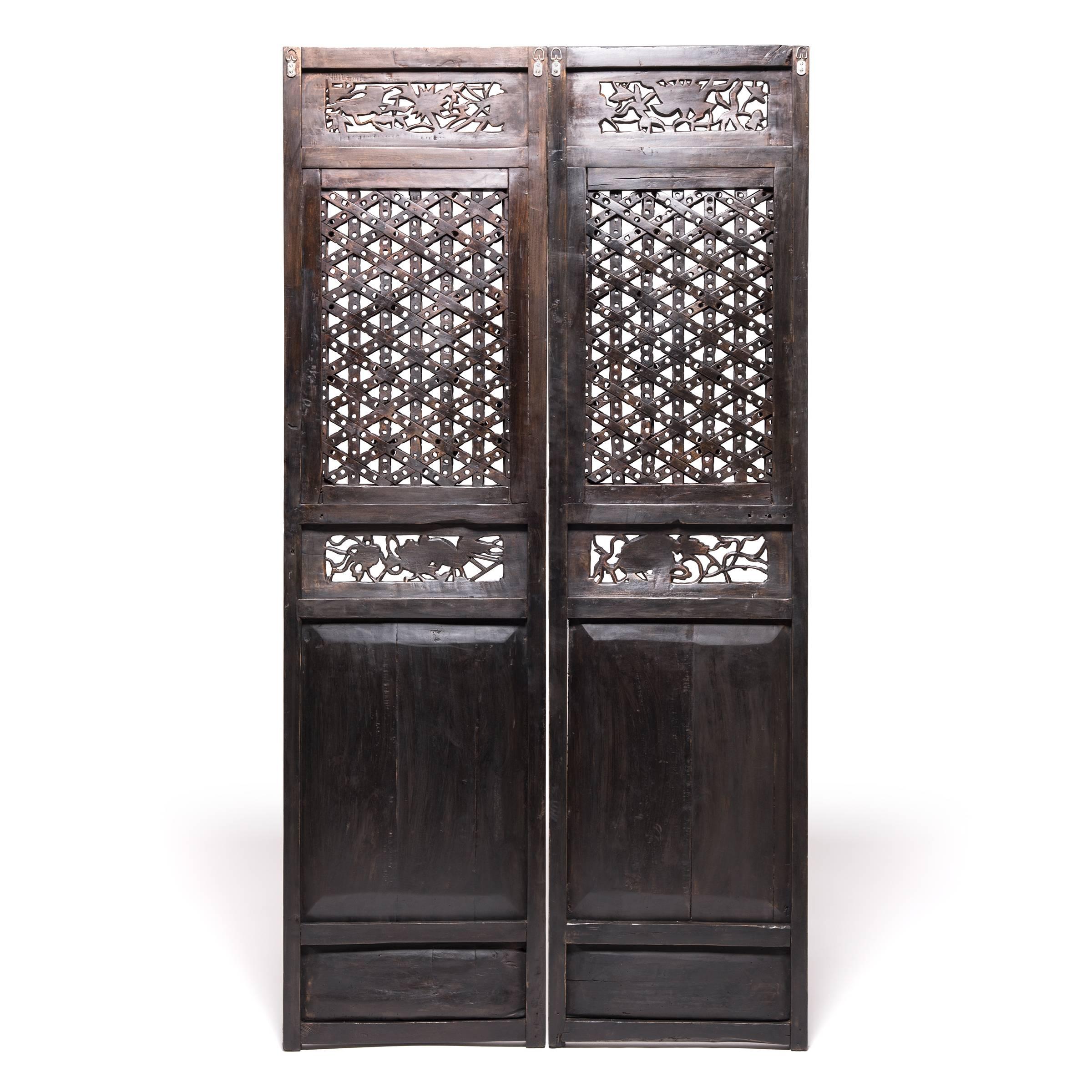 This pair of elaborately carved early 19th century Chinese courtyard panels feature intricately carved lattice comprised of chain links connected with floral blossoms. This complicated lattice pattern was brilliantly created by interlocking carved