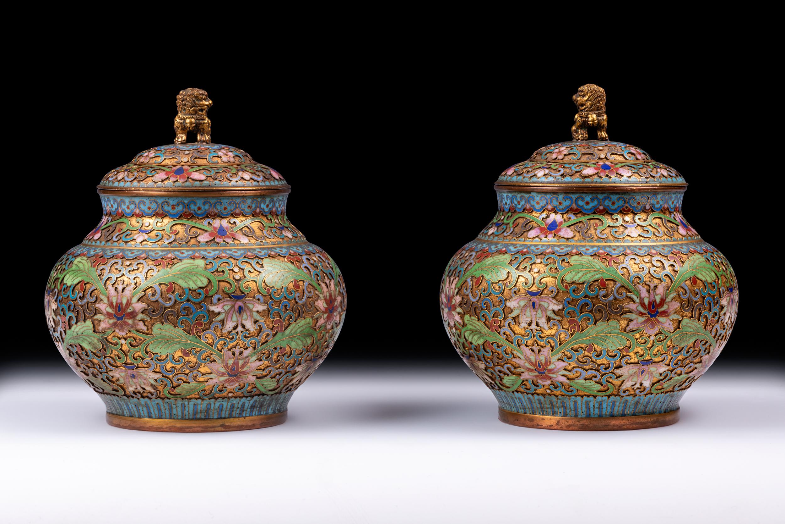 A stunning quality pair of Chinese Cloisonne enamel bowls and covers, each of globular form surmounted with Buddhist lions, the gilt ground overlaid with turquoise and coloured enamels with interspersed lotus flowers and leafy scrolls, on circular