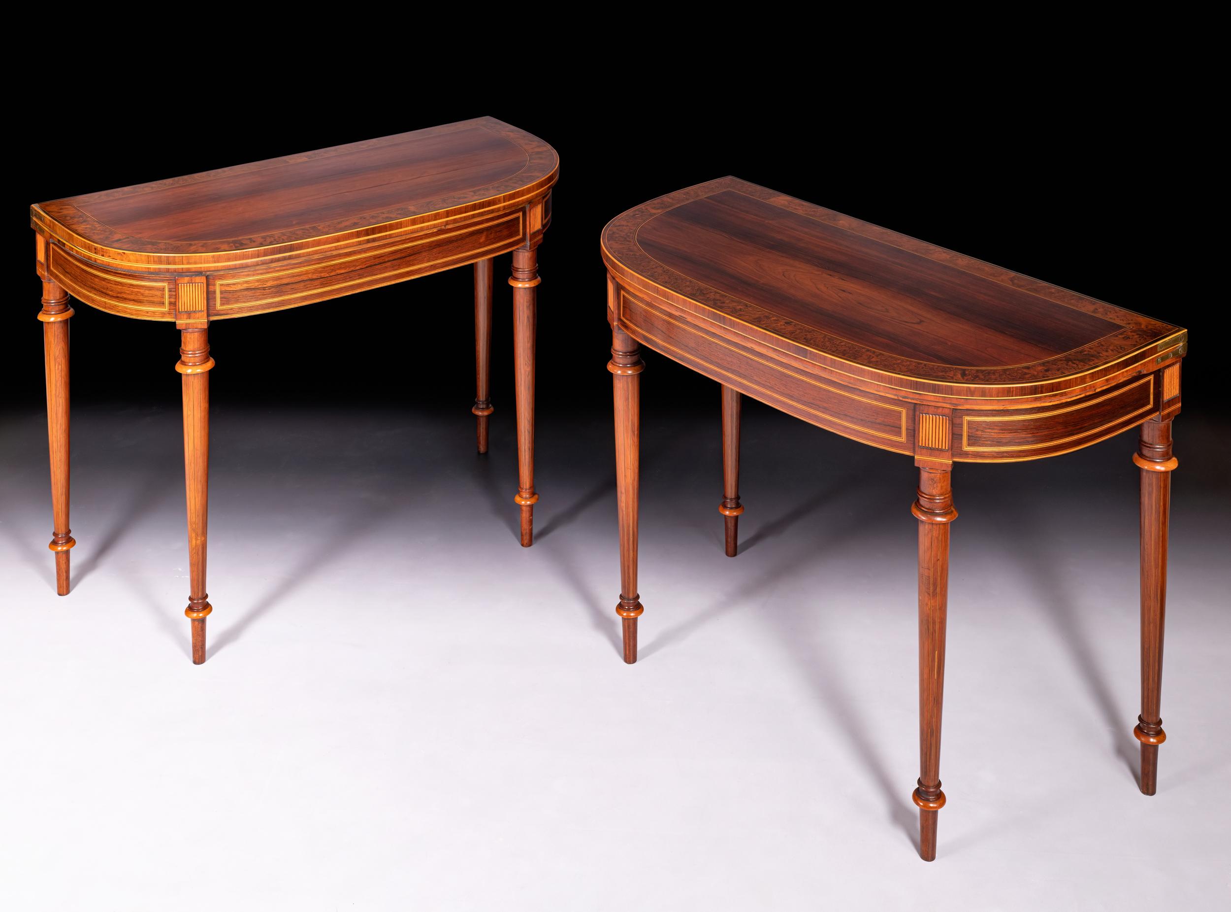 A stunning pair of Regency card tables, constructed in Rosewood and cross banded in Burr Elm wood the rectangular tops with rounded corners,  the fold-over tops enclosing a green baize interior, above a plain frieze paterae above each leg, raised on