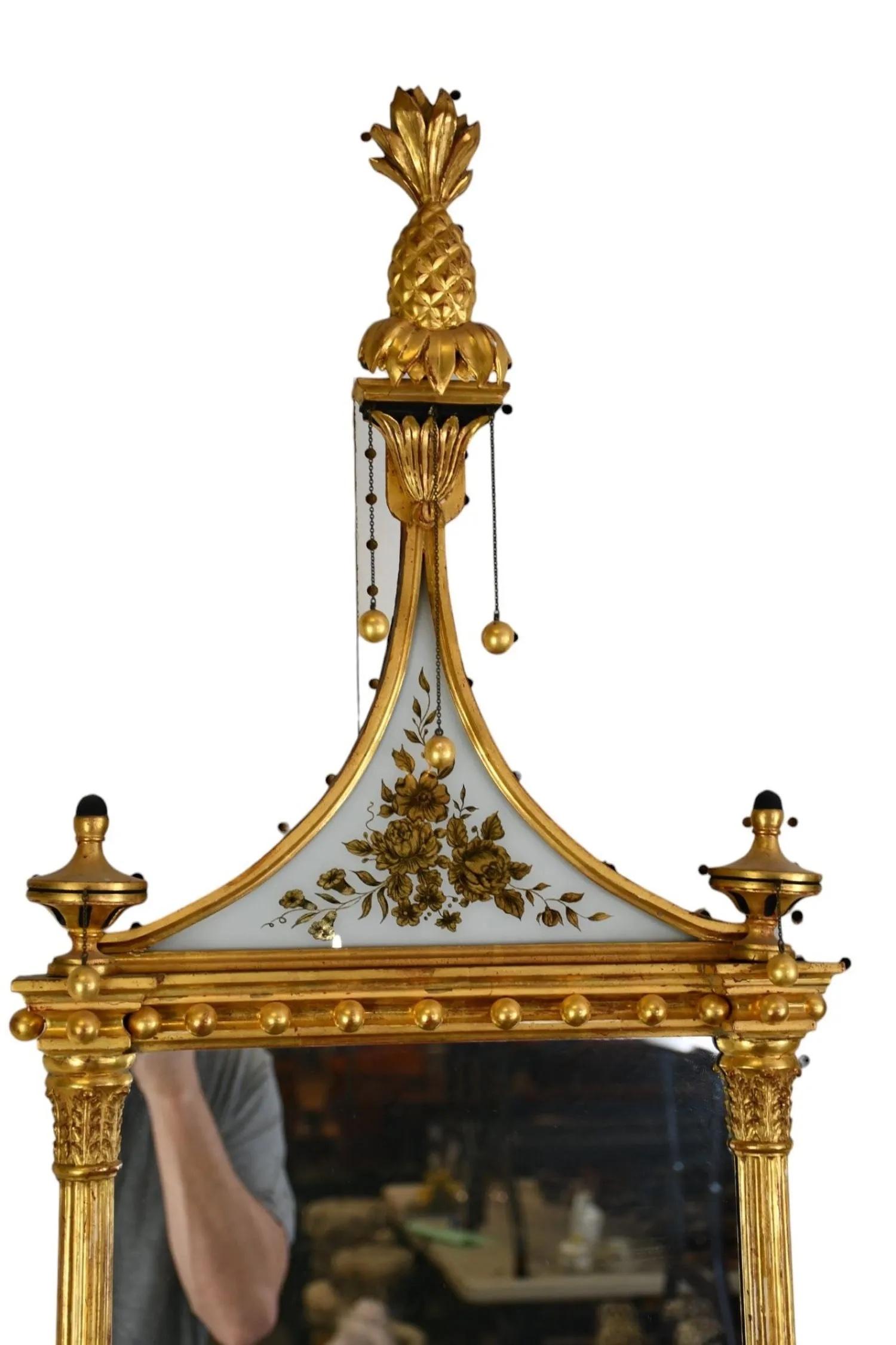 Pair of American Federal Hepplewhite Mirrors with Pineapple Finials.  Wonderful pediment shaped eglomise panels with floral gilt.  Gilded balls and columns.  A true pair. Possibly Albany, New York

Provenance: Purchased at The Winter Antique Show,