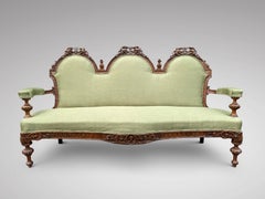 Paire de canapés serpentins français en noyer sculpté du début du XIXe siècle