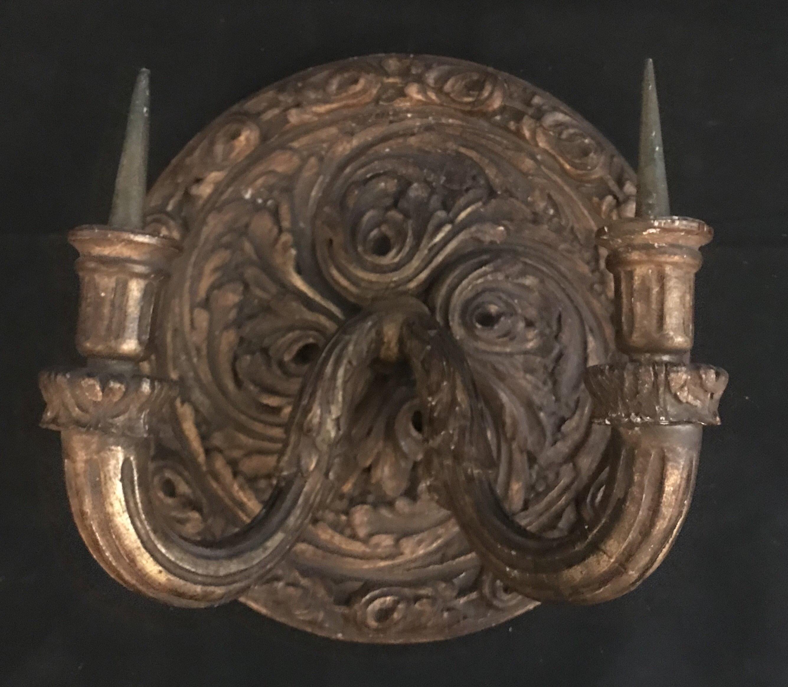 Decorate a living room, powder room or an entry way with this significant and elegant pair of early French wall lights. Crafted and hand carved in France circa 1800s or earlier, each sconce features hand carved scroll motifs at the pediment,