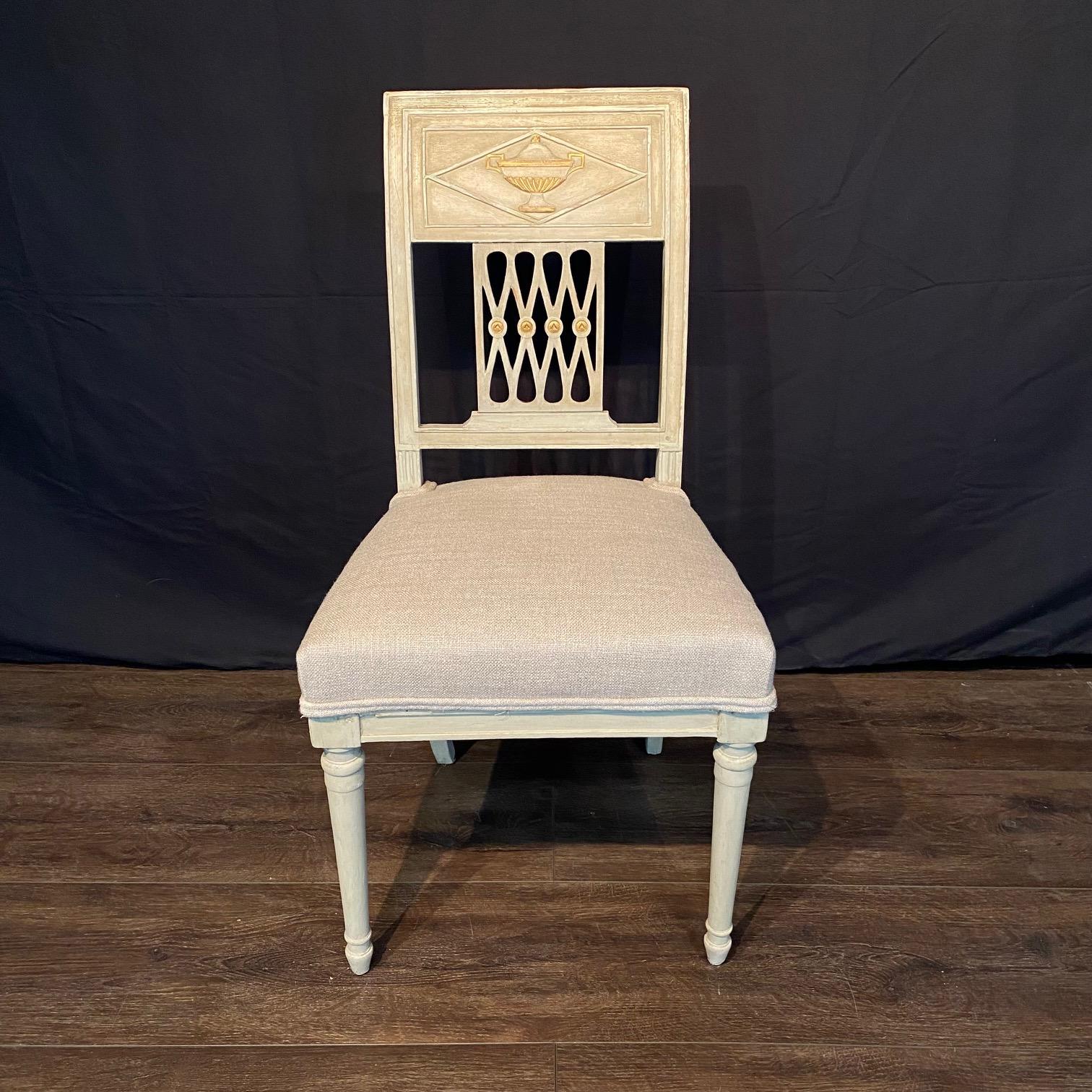 Elegant pair of late 19th century French Directoire period painted side chairs with their original patina. Lovely curved seat backs are detailed with a hand carved urn at each back top and a stunning woven pattern in the center with gold medallions.