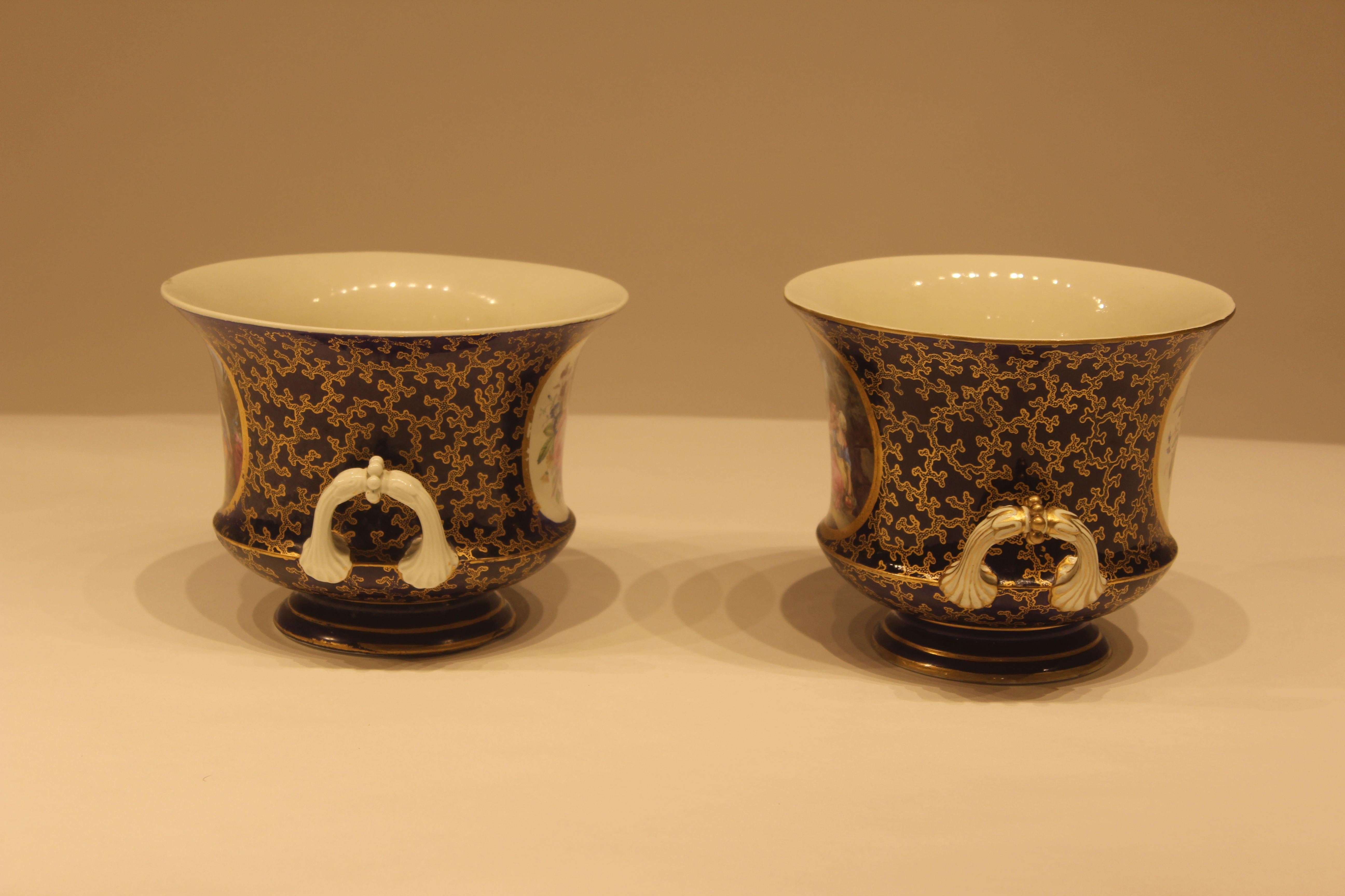 Pair of early 19th century hand painted serves cache pot with cobalt blue background and figural scenes and handles. Signed on the bottom, France.