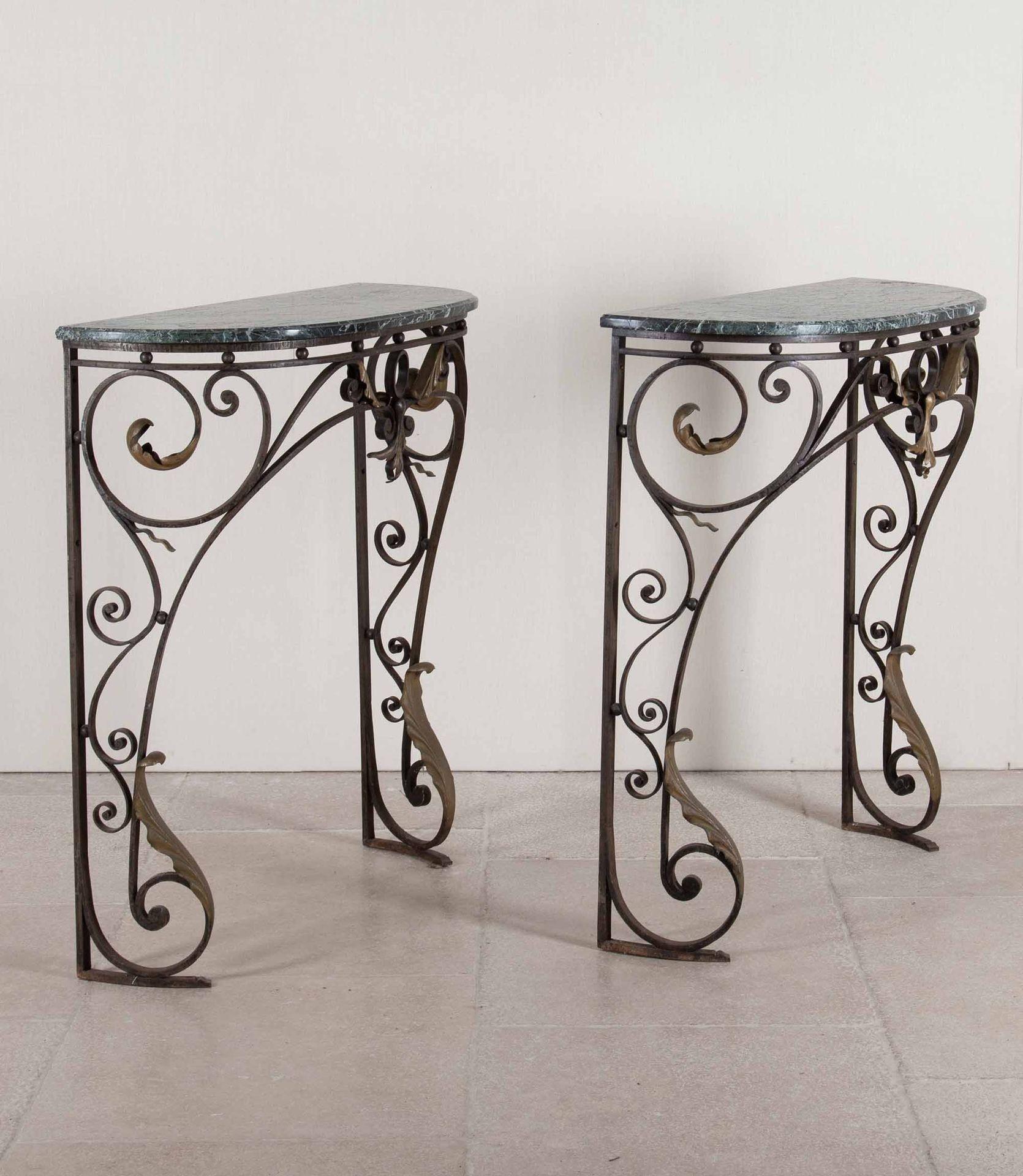 Paire de superbes tables consoles en fer forgé du début du 19e siècle. Avec une décoration de feuillage en laiton supportant des plateaux en marbre plus tardifs. Circa 1810.