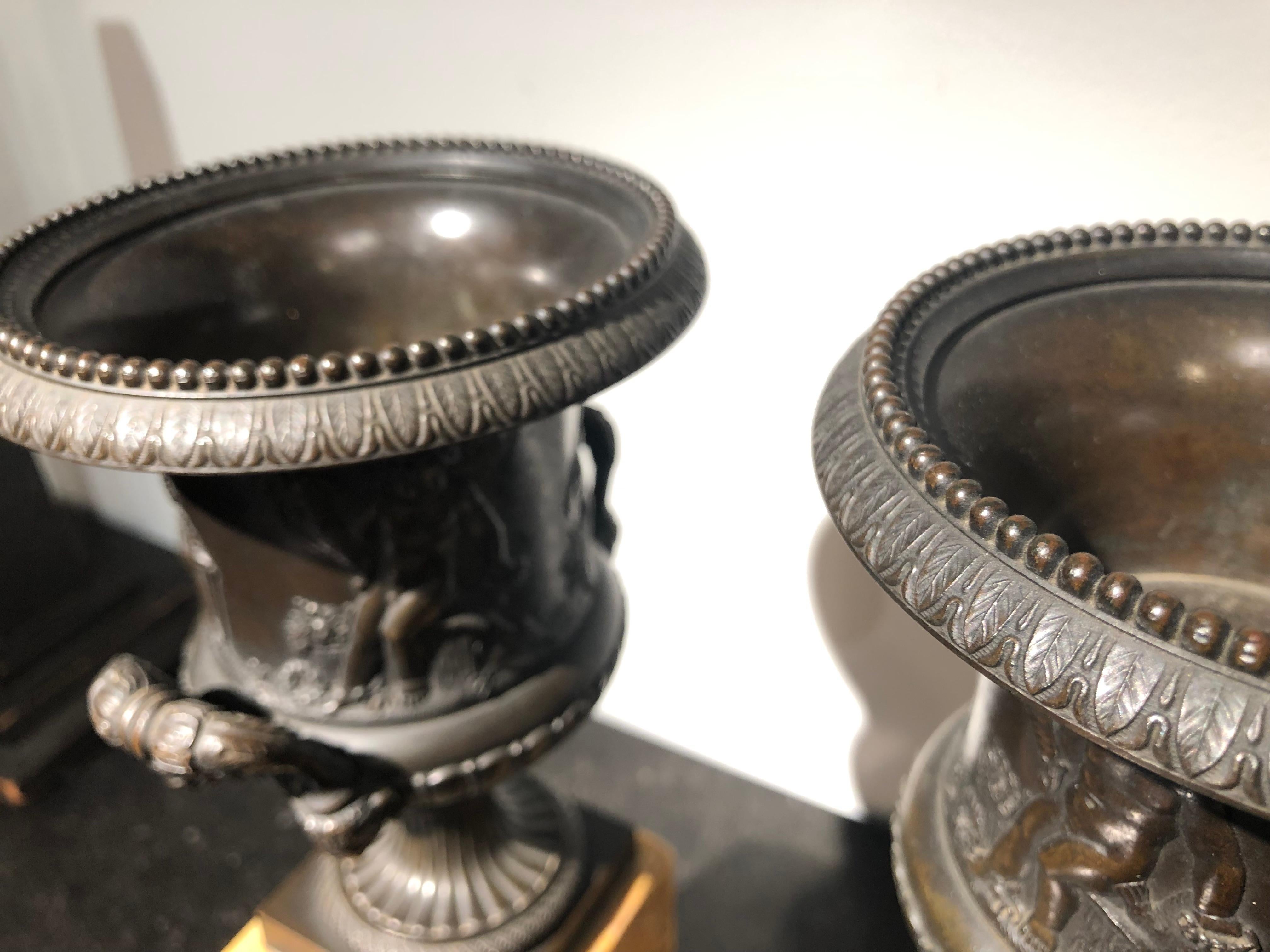 Patiné Paire d'urnes en bronze de style néoclassique français du début du 19e siècle sur piédestal en marbre en vente