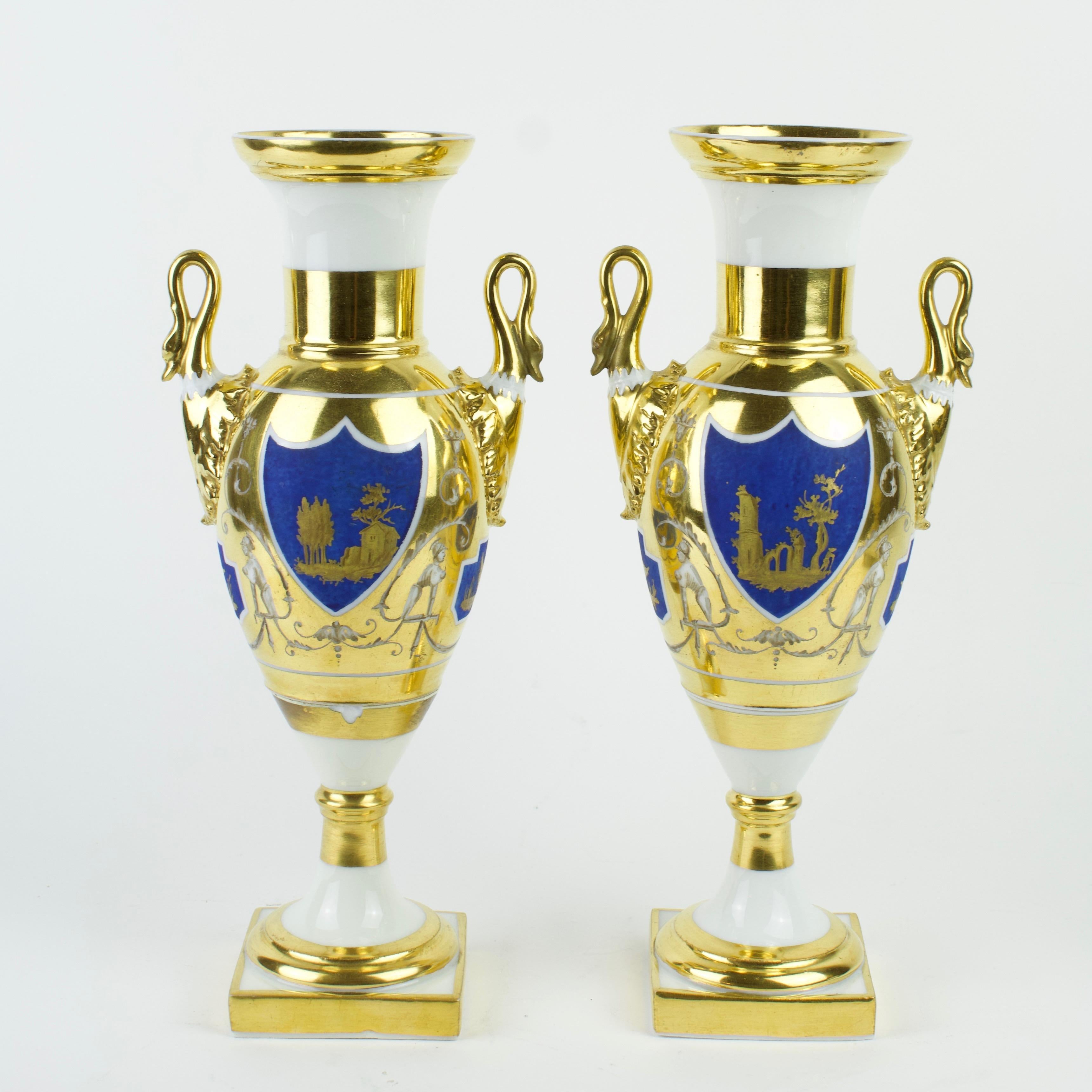 Pair of early 19th century French / Paris gilt and painted porcelain amphora vases

Ovoid body resting on a round foot with rectangular plinth; at the sides a pair of swan headed handles issuing from the body; long nack with broadend rim. White