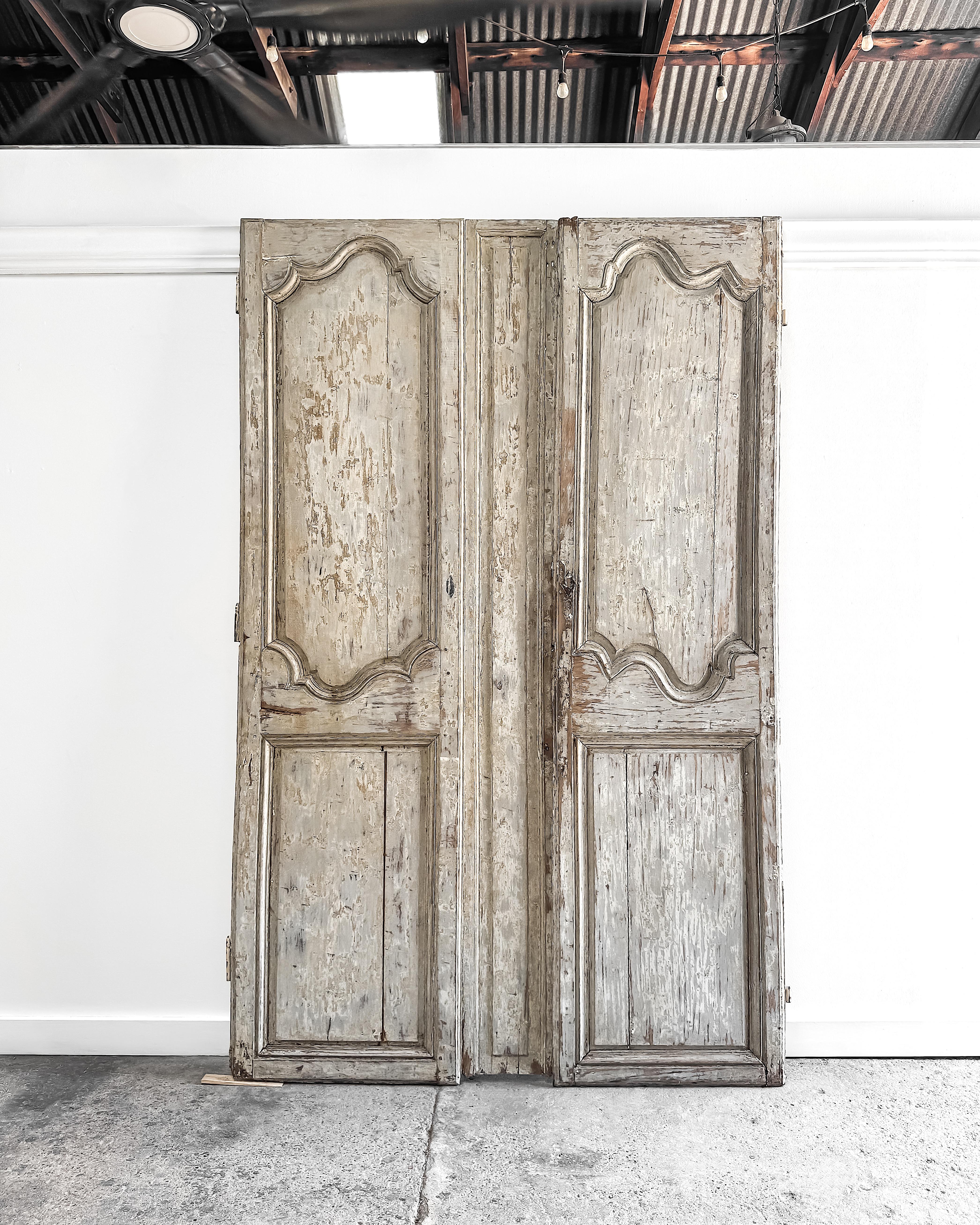 De principios del siglo XIX, este par de puertas de armario provinciales francesas ofrecen una belleza arquitectónica atemporal con su superficie raspada en seco que revela suaves capas de pintura crema, verde salvia y azul pálido. Los paneles